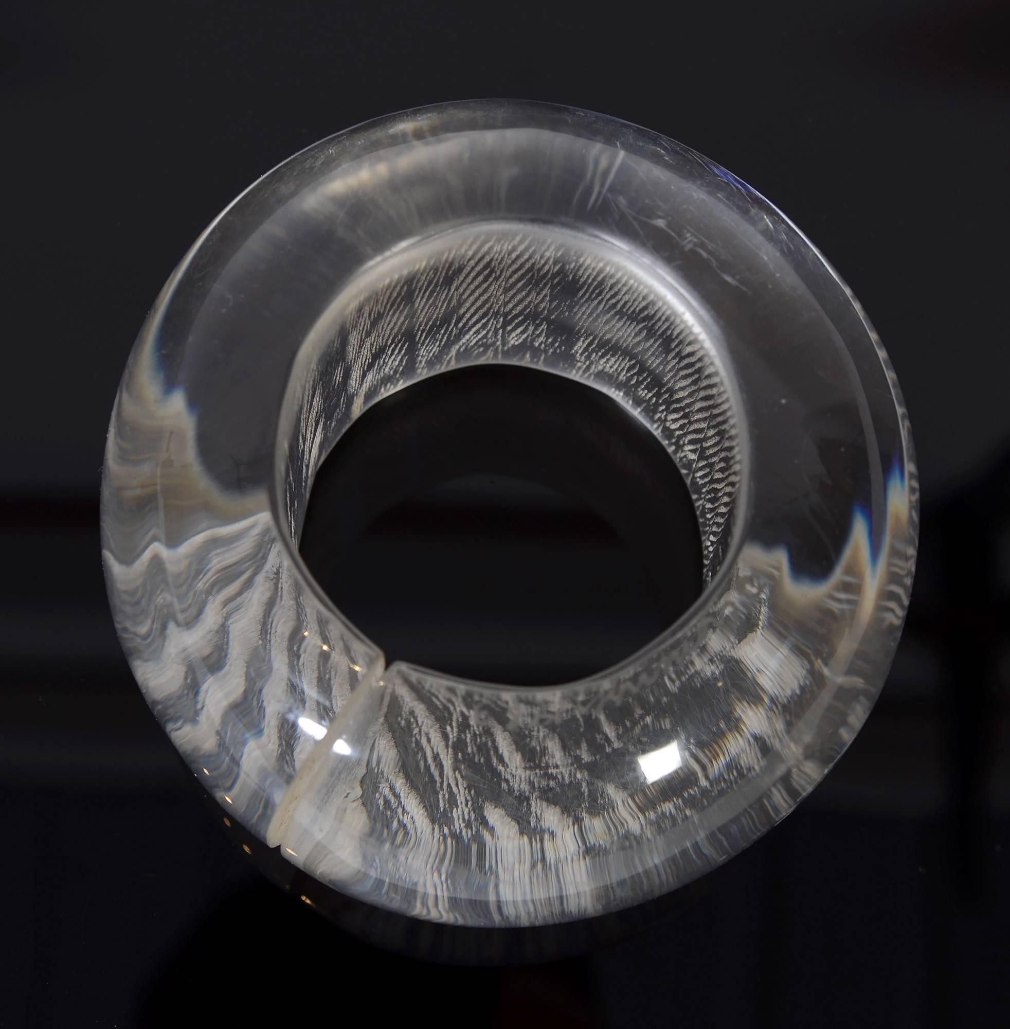 Enorme bracciale in lucite firmato  da Angela Cummings e datata 1983. L'interno presenta un disegno graffiato che si manifesta in modo diverso man mano che lo si gira. Il bracciale è molto pesante e tridimensionale. Il diametro dell'apertura è di