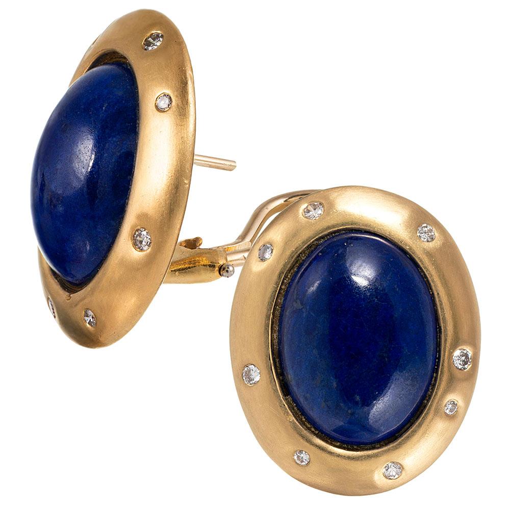 Whimsical and sophisticated earrings centered upon oval cabochons of lapis with round brilliant diamonds scattered on their golden frames. Made of 18 karat yellow gold and fitted for pierced ears, they can be converted to clips on request. 1 x .75