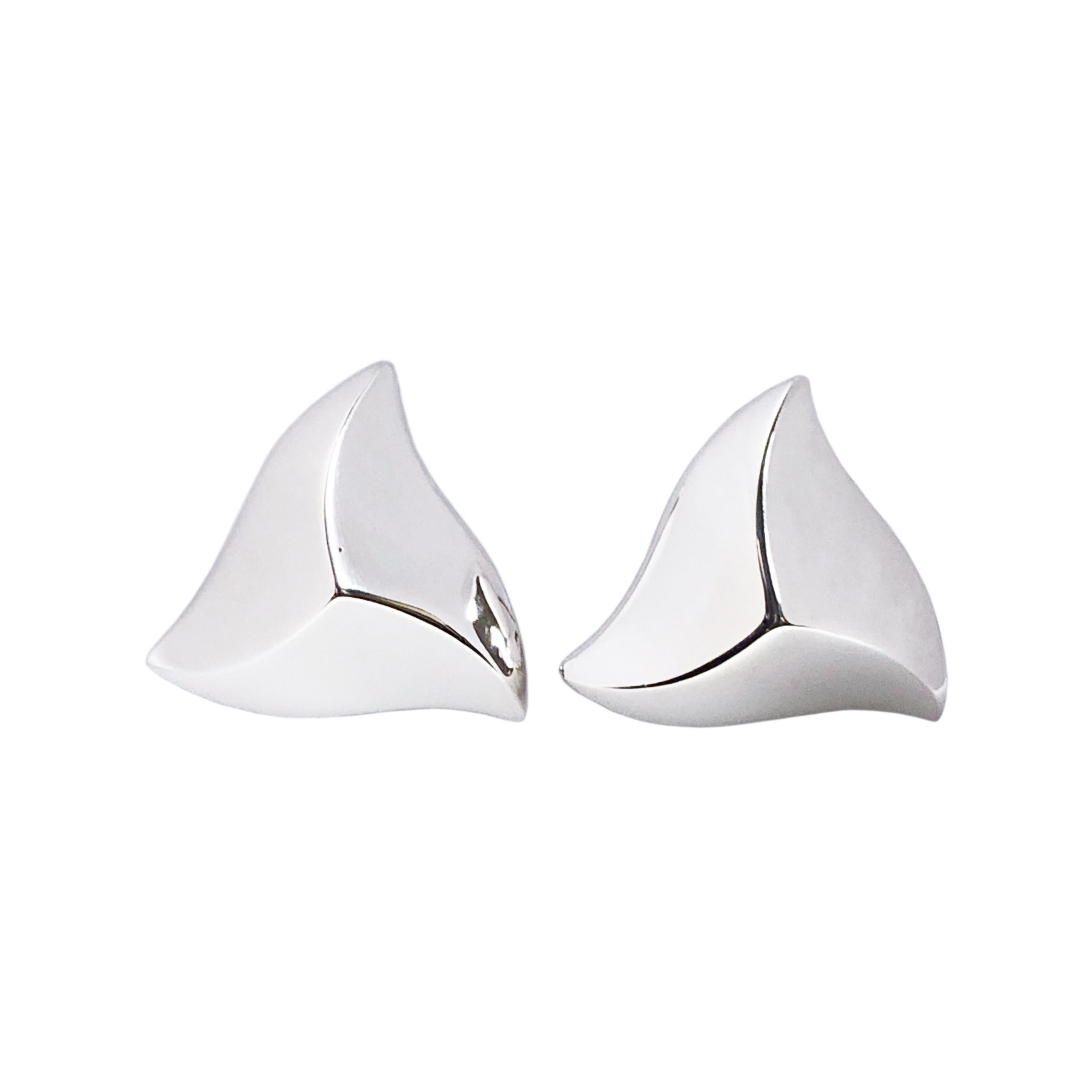 Circa 1980s Angela Cummings Sterling Silver Earrings, in a stylized Star shape, measuring 1 1/4 inch in diameter and 1/2 inch thick. Having Omega clip backs to which a post can be easily added if desired. These are in New unworn condition and come