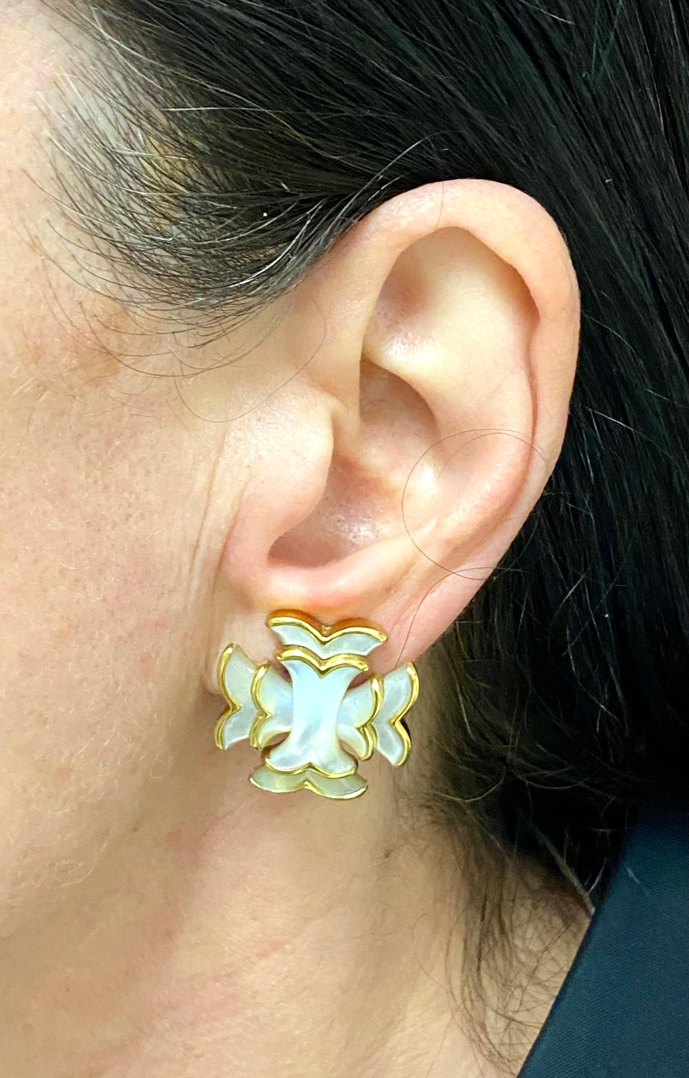 A pair of vintage Angela Cummings earrings made of 18k gold with mother of pearl inlay.
	The earrings designed as whimsical Maltese crosses. The mother of pearl inlay is staged in two layers divided by the gold curves. 
Mother of pearl makes these