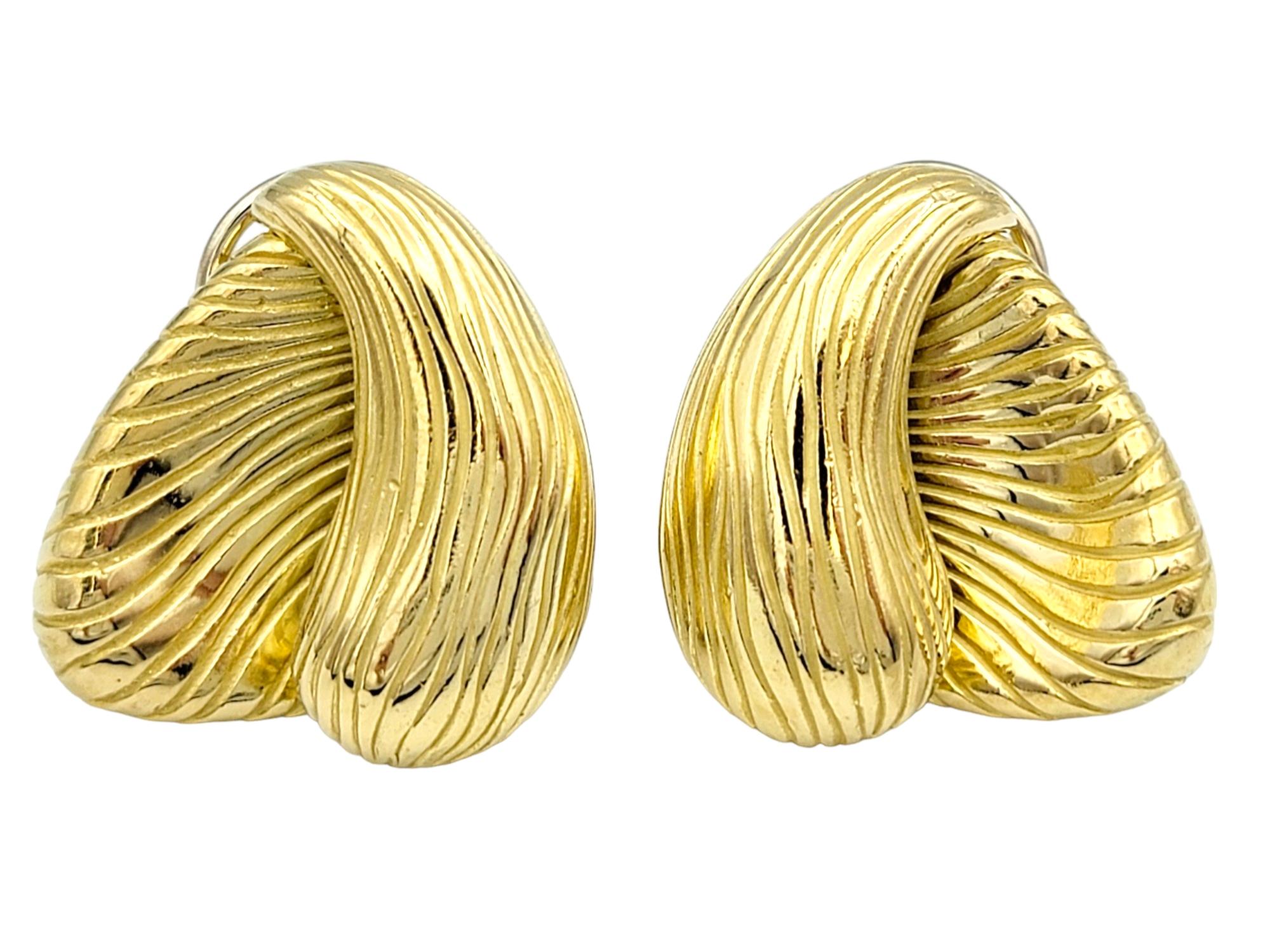 This vintage pair of Angela Cummings earrings crafted in 18 karat yellow gold exemplify her signature style, characterized by innovative designs and meticulous craftsmanship. The earrings feature a distinctive ridged and asymmetrical design. Each