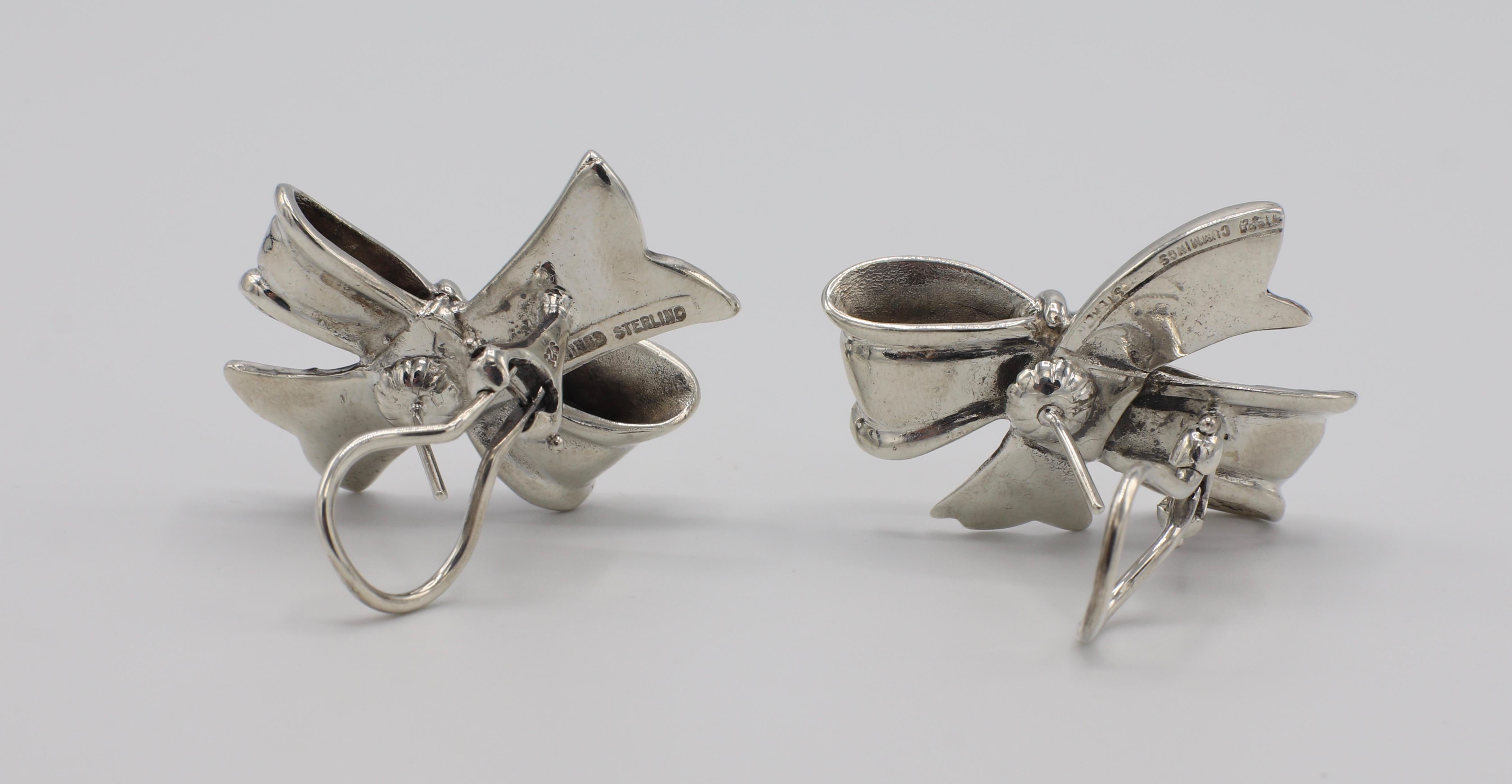 Vintage 1984 Angela Cummings Sterling Silver Bow Earrings 

Metal: Sterling Silver 925
Weight: 17.51 grams
Width: Approx. 30mm 
Length: Approx. 22.6 mm
Backs: Lever backs with posts 
Signed: 