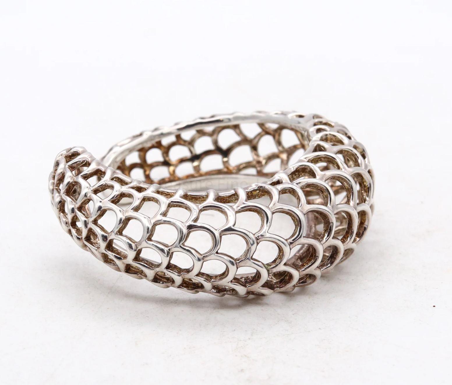 A geometric wired cuff designed by Angela Cummings.

Beautiful aerodynamic wired cuff bracelet, created by Angela Cummings at her studio in New York City back in the 1991. It was carefully crafted in solid .925/,999 sterling silver with high