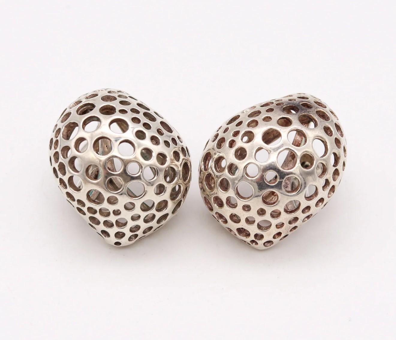 Pair of Perforations earrings designed by Angela Cummings.

Beautiful sculptural pair, created by Angela Cummings at her goldsmith studio in New York city, back in the 1981. These modernist and bold earrings has been crafted with free-forms holed
