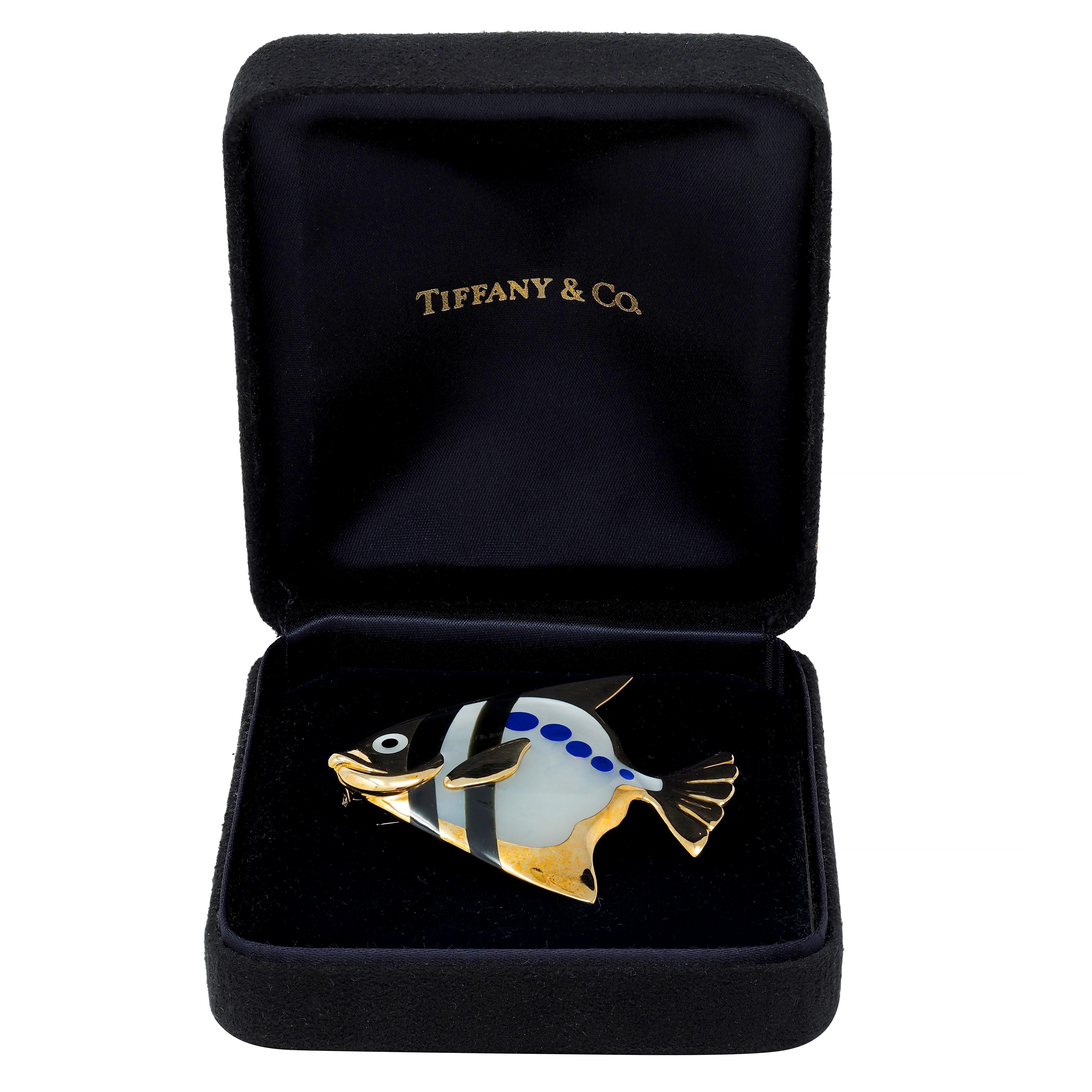 Designed as a stylized angel fish with a fluted tail, pointed fins, and raised mouth
With an inlaid body comprised of lapis lazuli, onyx, and mother-of-pearl
With lapis lazuli spots - opaque ultramarine blue with gold pyrite