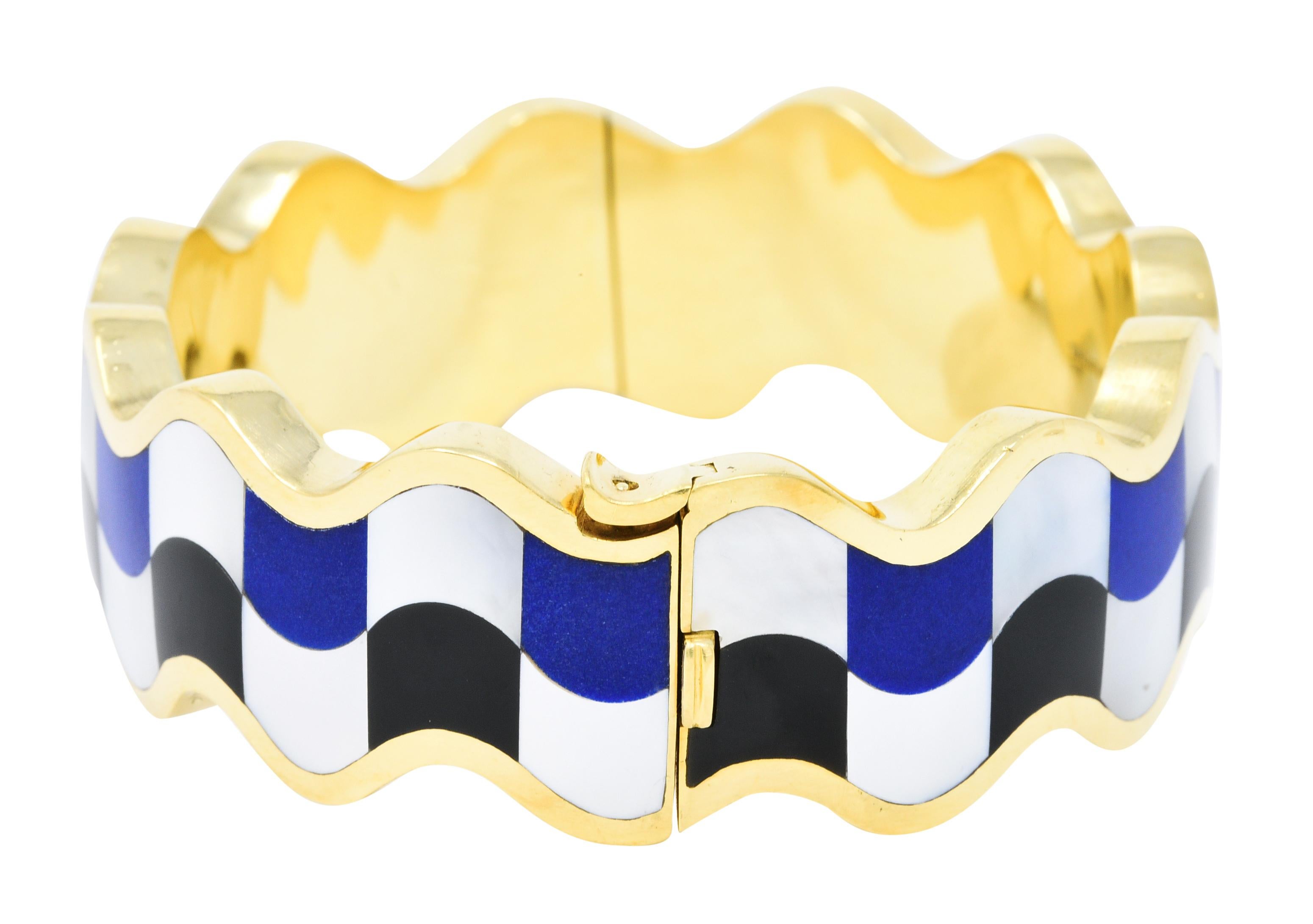 Wavy edged bangle bracelet features an inlaid checkerboard motif

With opaque lapis lazuli, opaque black onyx, and iridescent white mother-of-pearl

Bangle opens on a hinge with the pattern uninterrupted

Completed by a concealed clasp with a fold