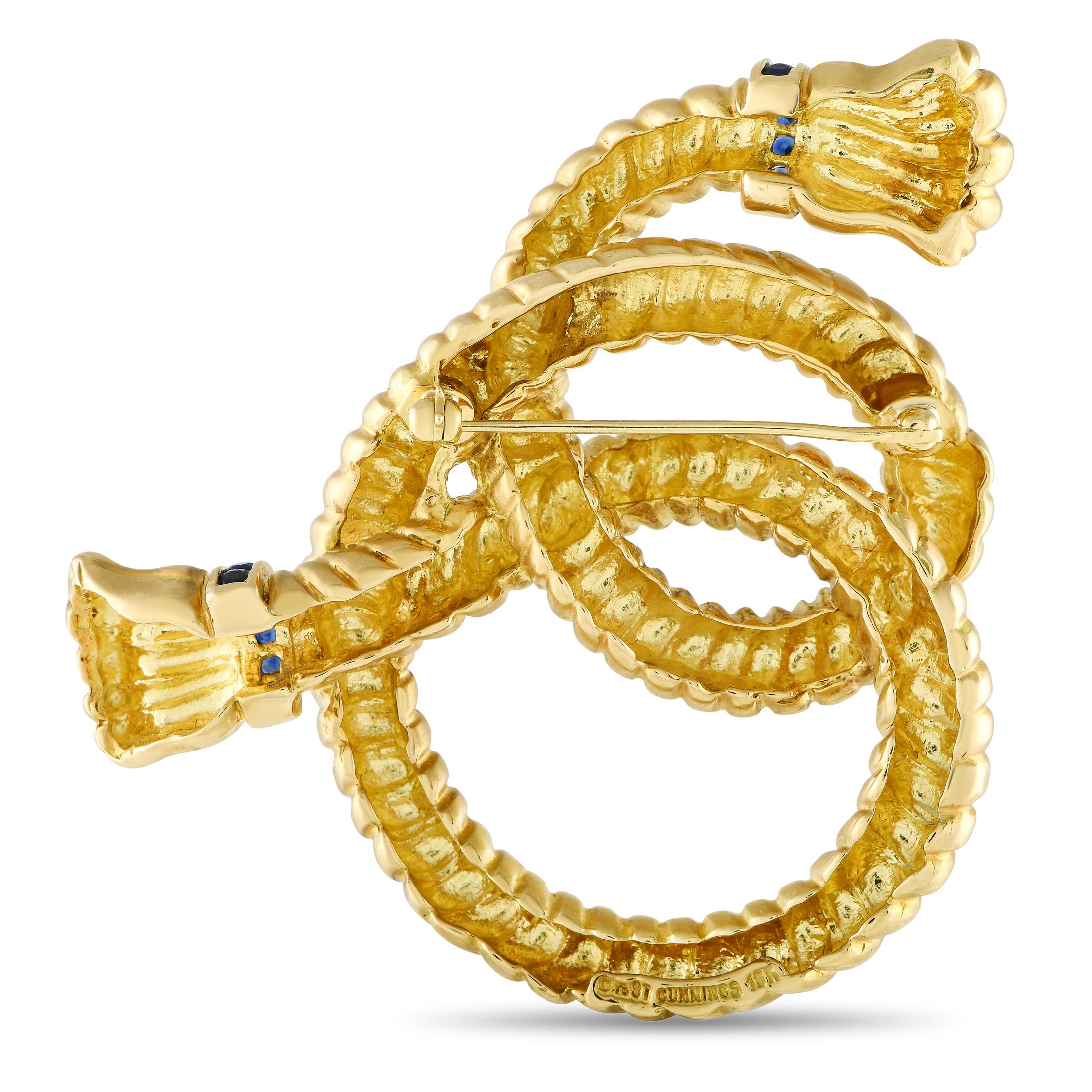 This artistic vintage Angela Cummings brooch will add a touch of luxury to any ensemble. Designed to resemble a knotted rope, this breathtaking accessory is crafted from opulent 18K Yellow Gold and includes subtle sapphire accents at each end. It