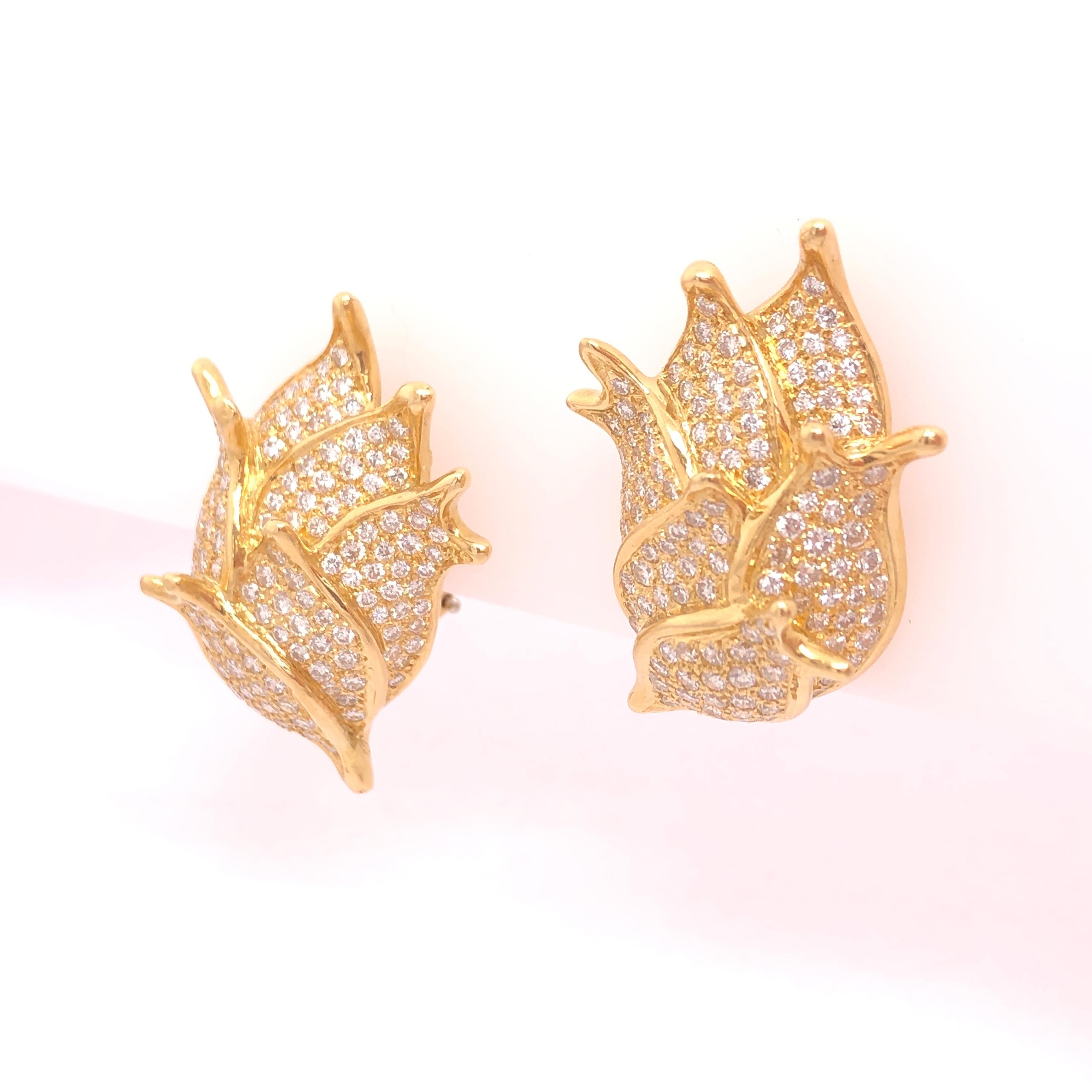 At first glance this beautiful pair of earrings resemble a flower bud or sea shell. Upon closer inspection you start to realize the earrings are composed a cluster of diamond encrusted fish. The total diamond carat weight is approximately 3.50 CT.