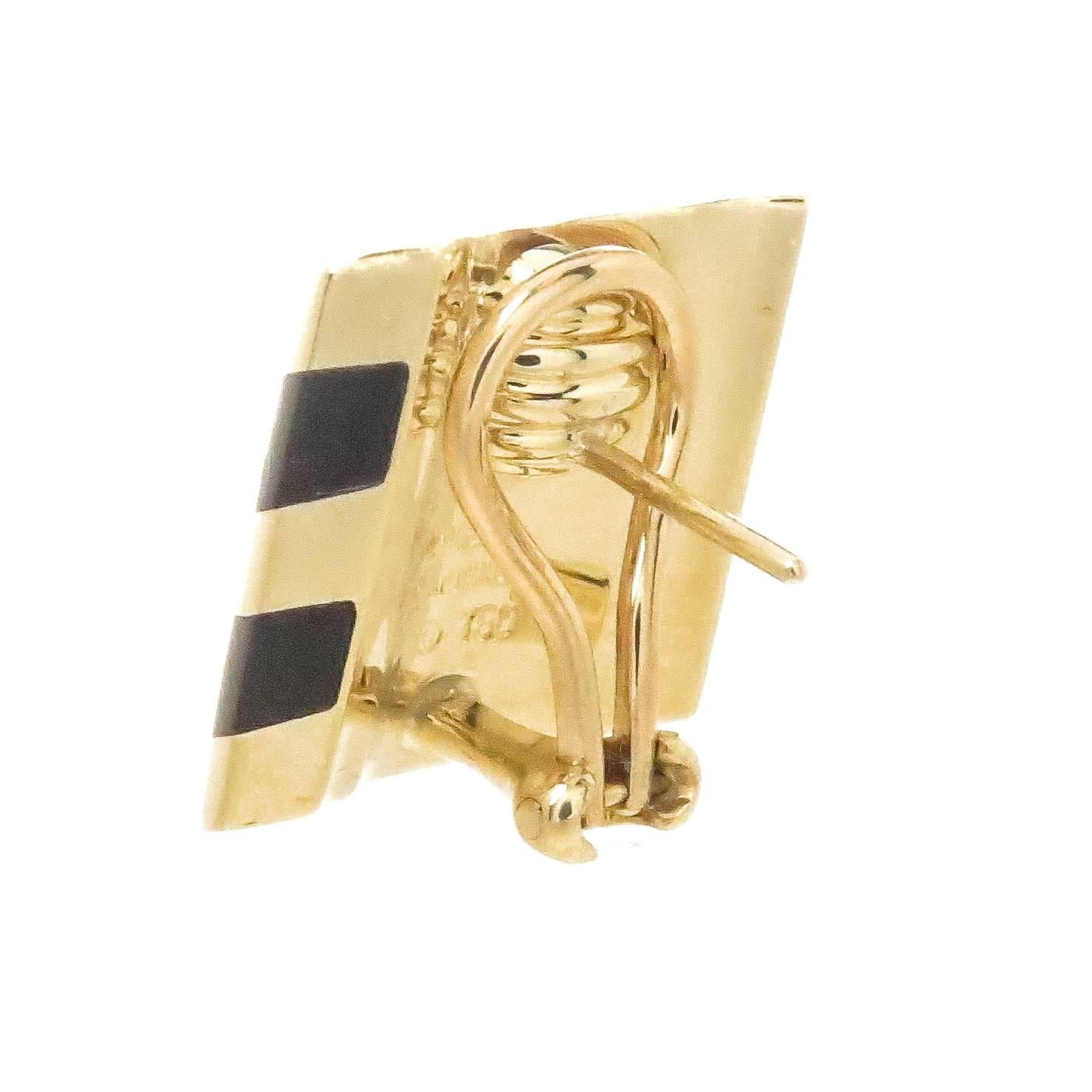 Circa 1980s Angela Cummings 18K yellow Gold Earrings, having a wave design the earrings measure 3/4 X 3/4 inch, 2 stripes of inlayed Black Onyx stone. Omega clip backs with a post.