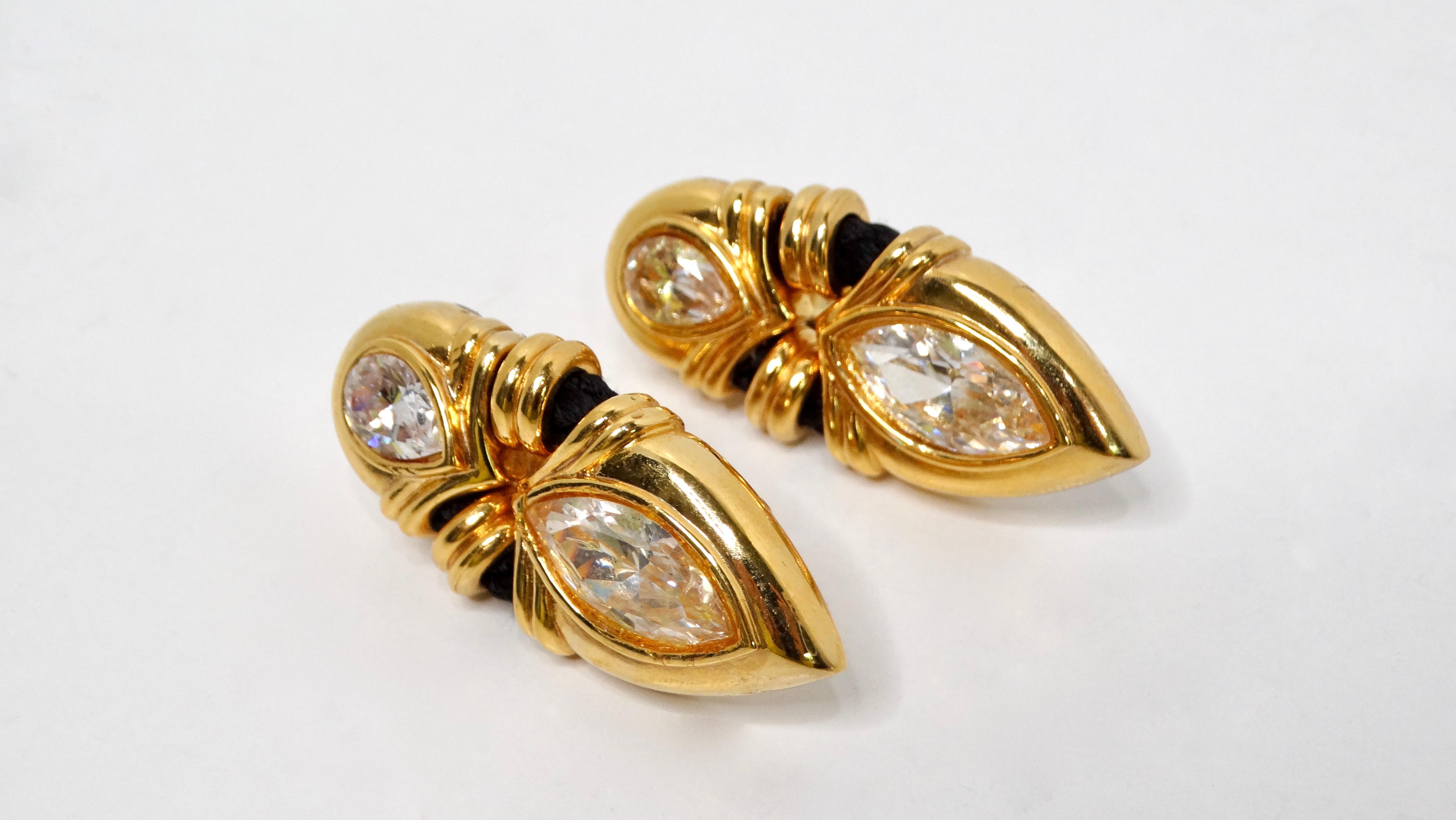 Elevate your accessory game with the Angela Kramer Vintage 18k Gold Plated Rhinestone & Black Rope Clip-On Earrings, a stunning blend of vintage charm and modern design. These exquisite earrings showcase a chic gold-plated drop silhouette adorned