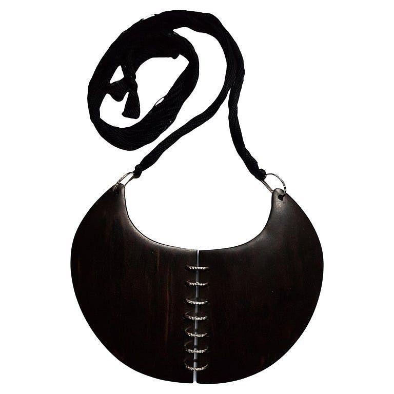 Ce collier exceptionnel et unique est une pièce d'art moderne des années 80 réalisée par Angela Pintaldi.
Il est composé de 2 feuilles de bois dur maintenues ensemble par des pinces en or blanc ornées de diamants de taille ronde.
Sur le côté de