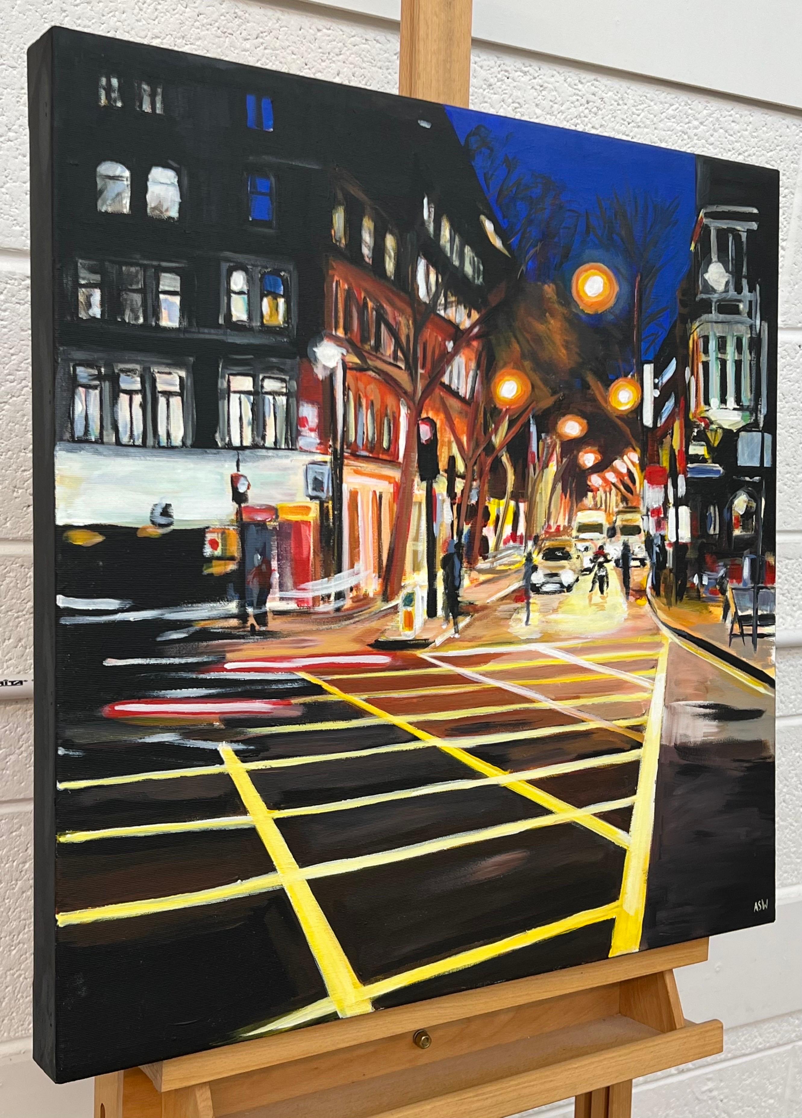 Escena nocturna de la calle New Cross de la ciudad de Londres por el artista británico de paisajes urbanos - Painting de Angela Wakefield