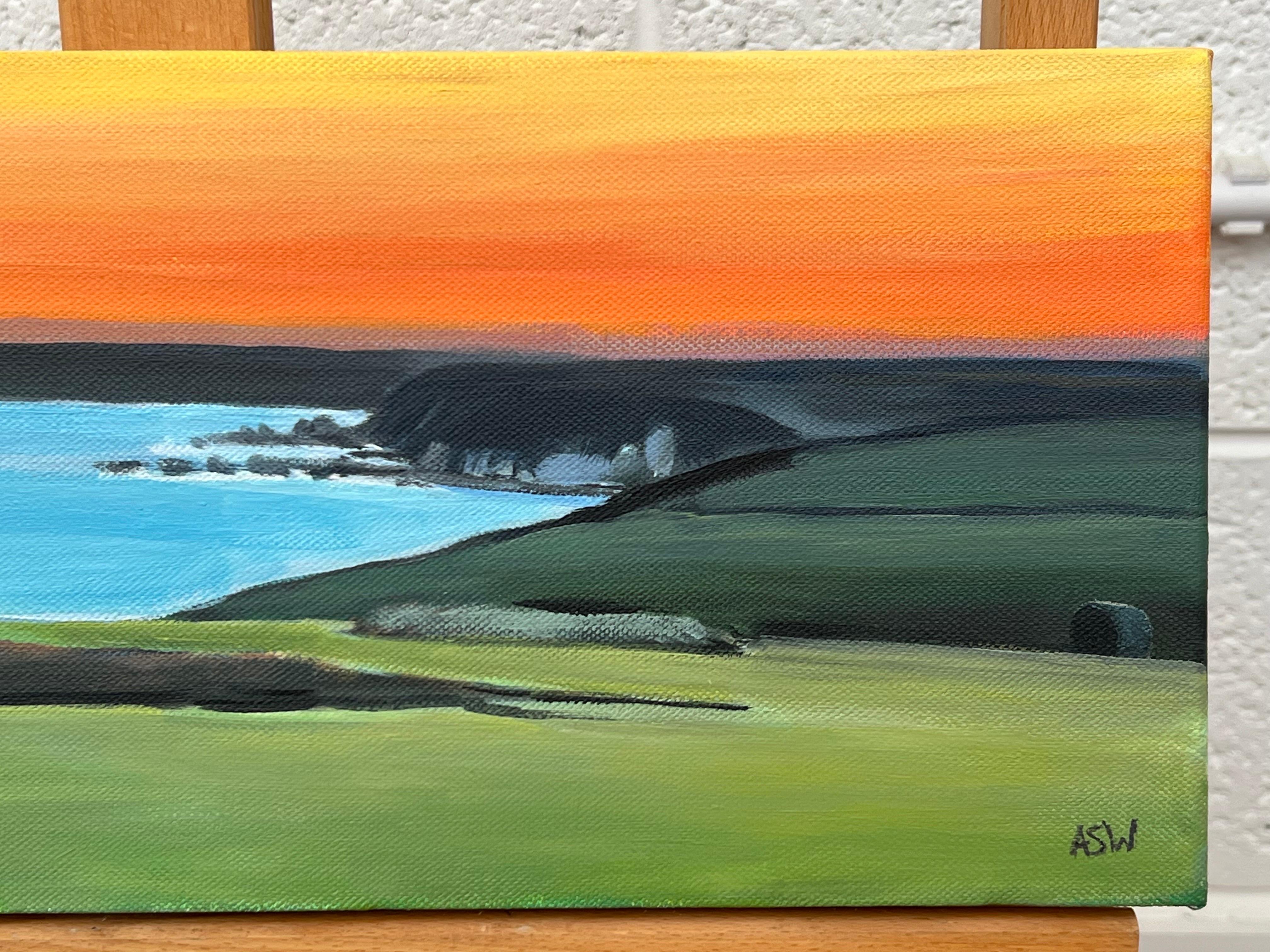 Escena panorámica de la costa de Devon con puesta de sol naranja en el Canal de la Mancha en venta 1