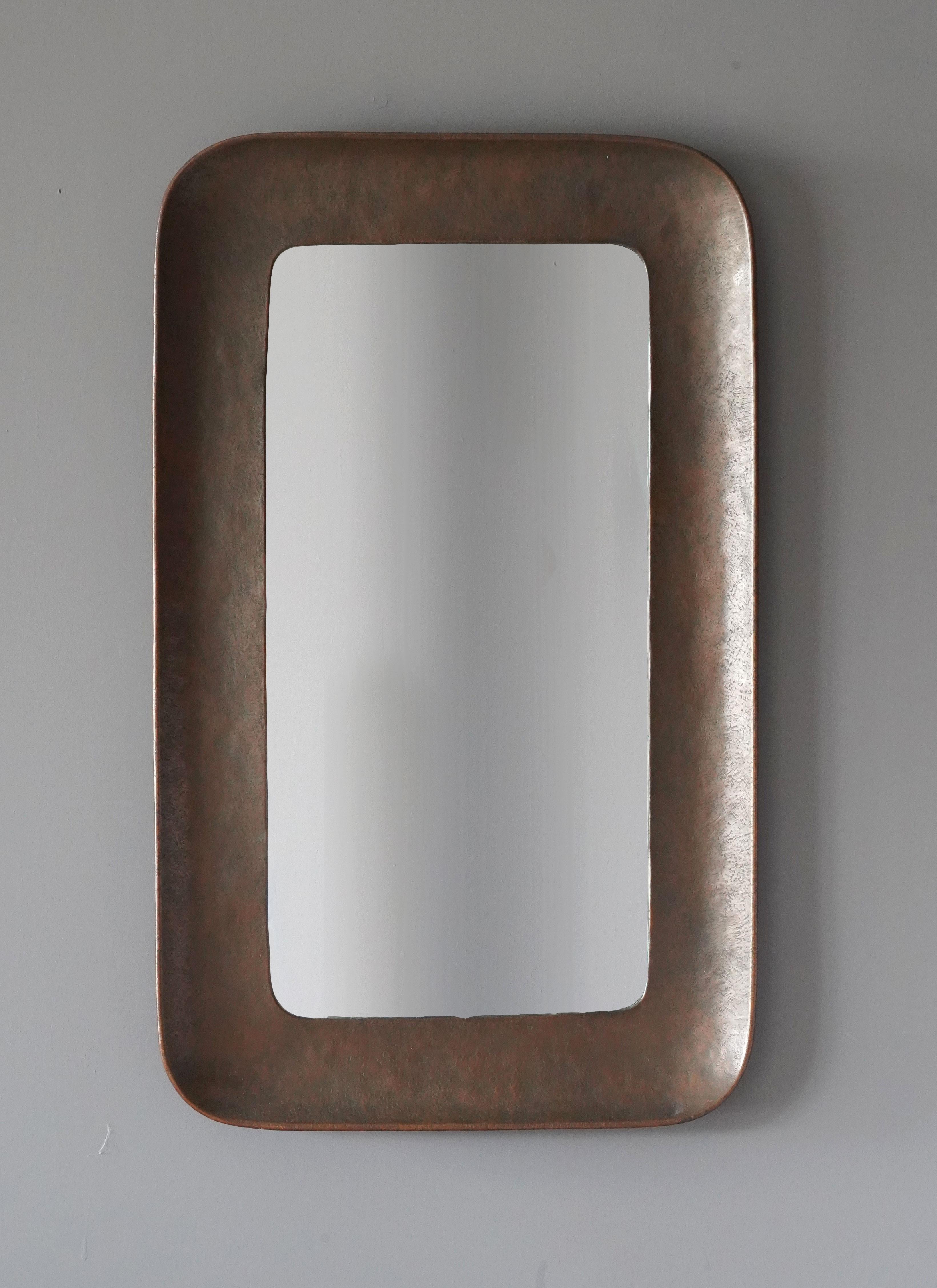 A sizable wall mirror, designed and produced by Angelo Bragalini, Italy, 1950s. In burnished copper, original mirror glass.

Other designers of the period include Fontana Arte, Max Ingrand, Gio Ponti, Seguso, and Franco Albini.