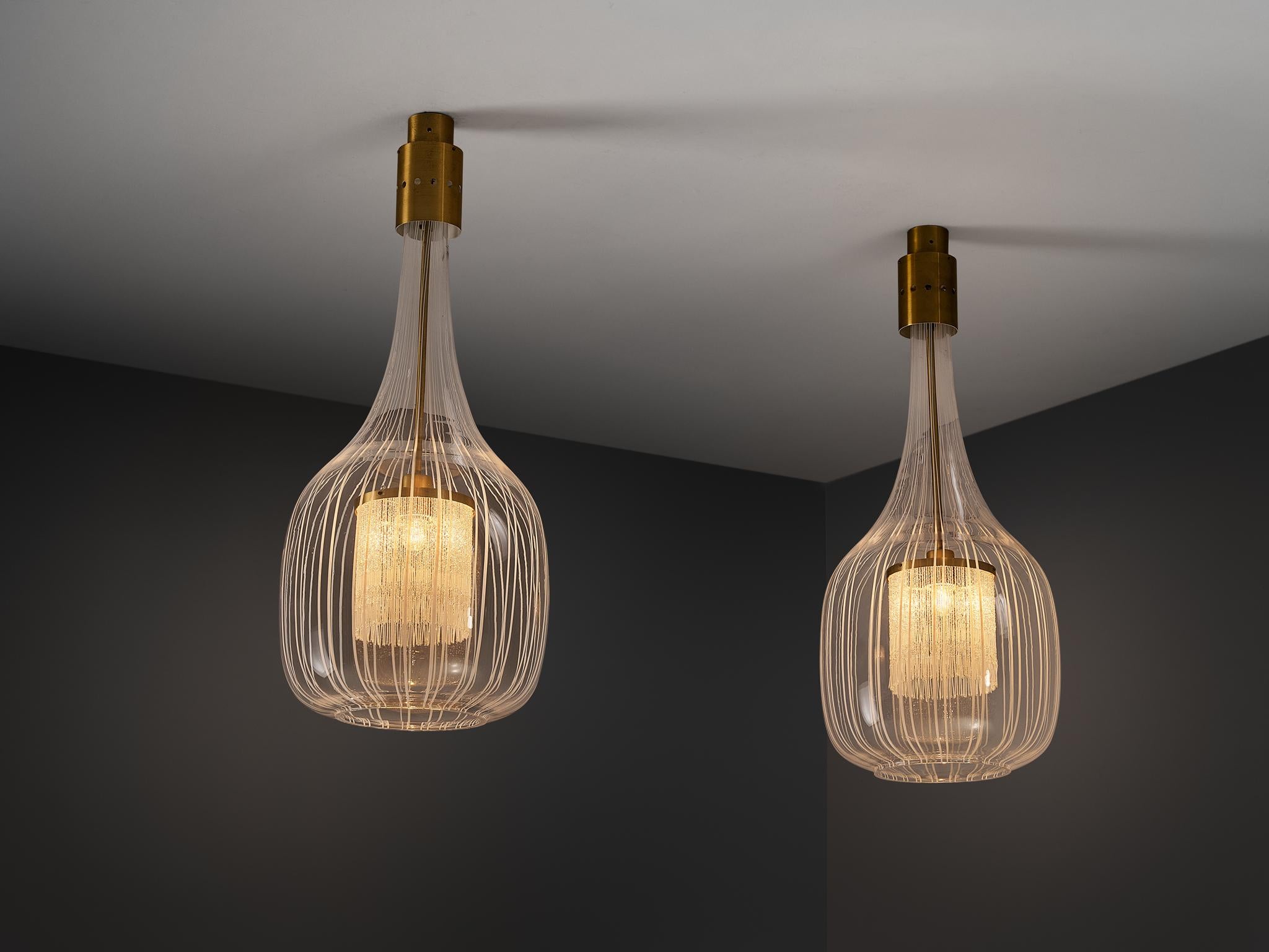 Angelo Brotto per Esperia, lampade a sospensione, vetro, ottone, Italia, anni '70

Eleganza in ogni aspetto, il design di Angelo Brotto cattura l'attenzione. Sospesa da un apparecchio in ottone, una lanterna in vetro di Murano è al centro della
