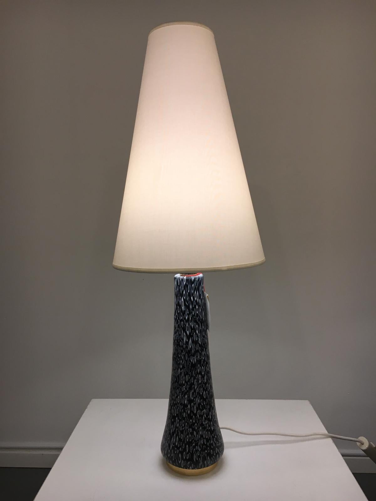 This elegant table lamp, model “Hermes”, is an original vintage piece by Angelo Brotto, manufactured by Esperia in Italy, circa 1980.

The base of the lamp is made of high quality, deep blue Murano glass with a lovely detailed pattern within the