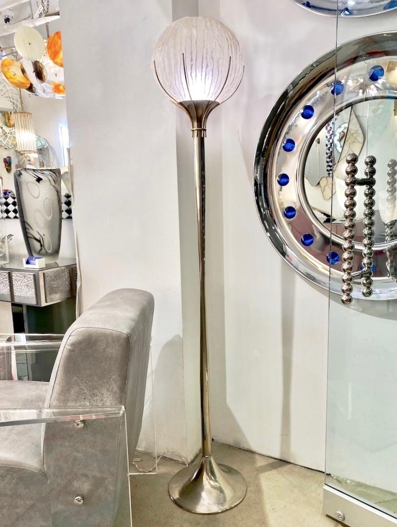 Early 1960s organic modern floor lamp by Angelo Brotto, a streamlined design with a curvilinear pillar in polished nickel, supporting thin brass rods to embrace a blown satinated Murano glass globe, worked with a corrugated pattern in a very organic