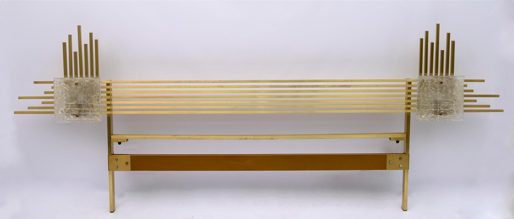This double headboard was designed by the famous designer Angelo Brotto for the Murano glass factory, Esperia.
It is made of brass and Murano glass tiles that act as dimmable lamps.
The size of this headboard allows you to combine double bed bases