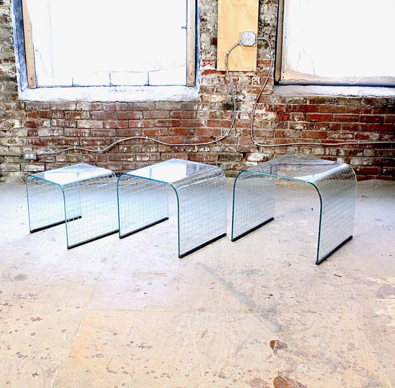 A great set of 3 Italian modern curved glass stacking tables.

Designed by Angelo Cortesi for FIAM.

The tables each have etched grids to the underside and their original black wooden feet or cleats.

Each retains a (well worn) FIAM label near the