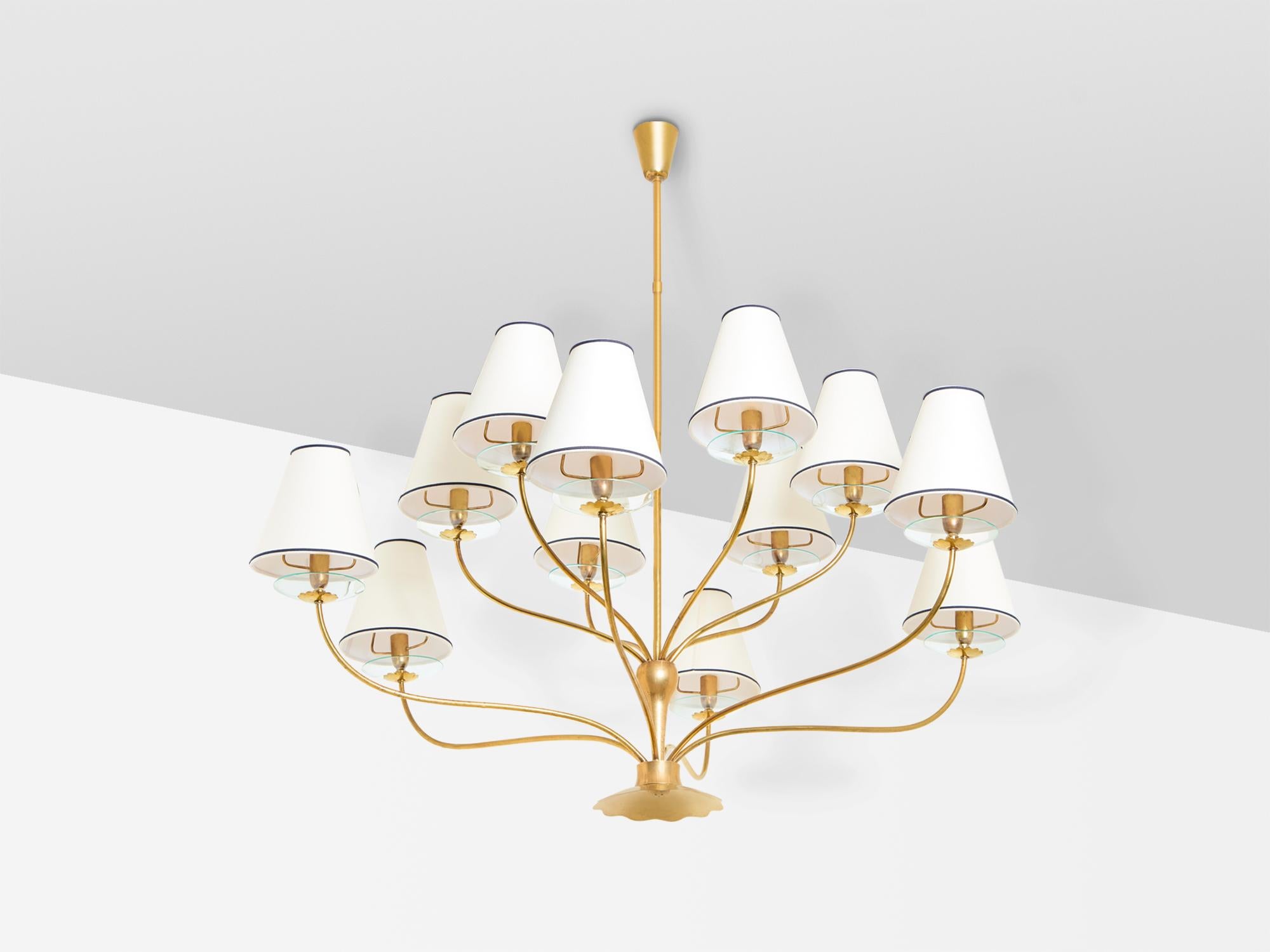 This superb chandelier was designed by Angelo Lelii for Arredoluce in the 1940s. It consists of 12 brass arms, with beautiful crystal glass discs atop, brass sockets and off white and black shades. The design is reminiscent of later Persane lighting