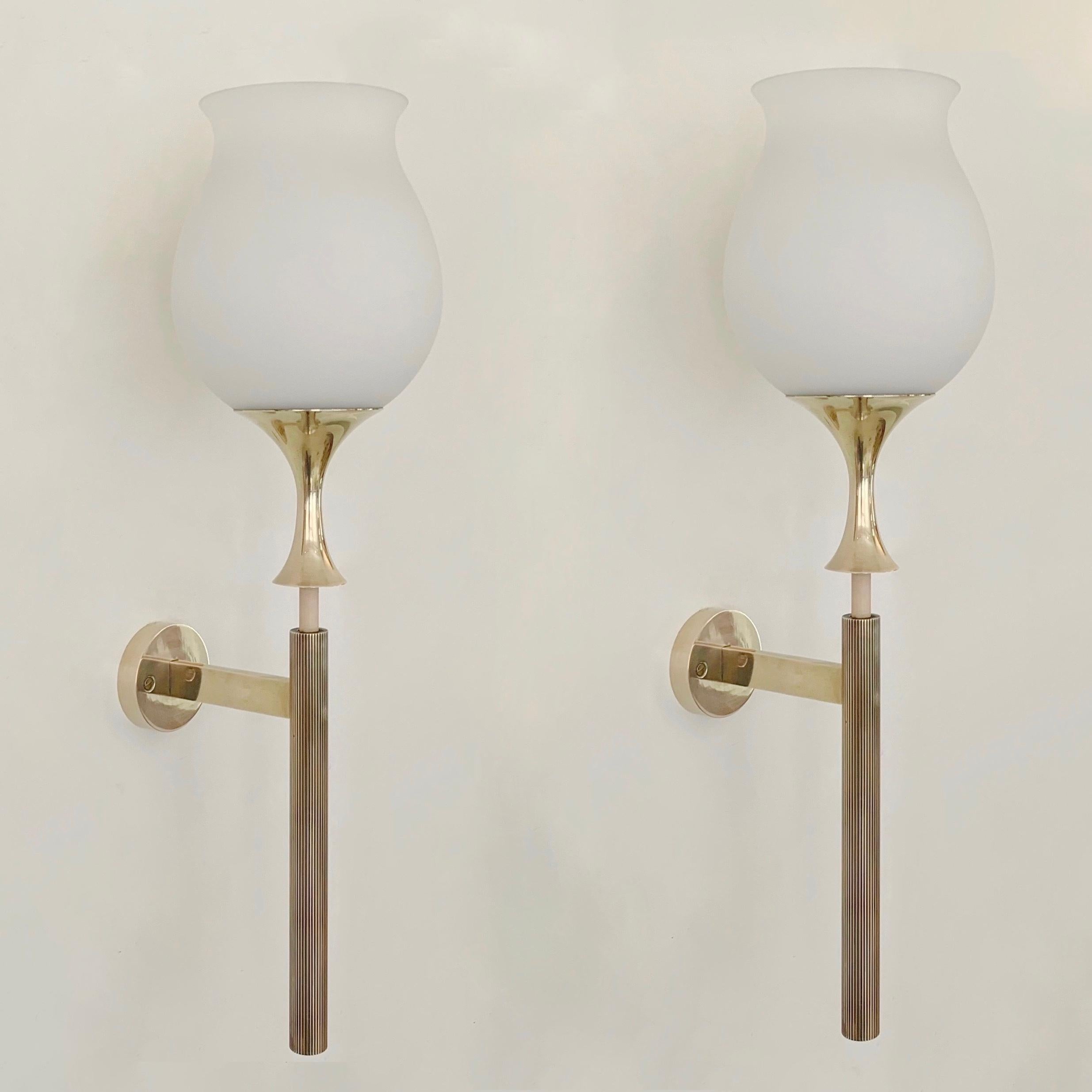 Elegantissima coppia di appliques di Angelo Lelii per Arredoluce, circa 1956, Italia.
Ottone lucido, vetro opalino originale bianco.
Lampadina E27. Cablaggio controllato.
Con il timbro 
