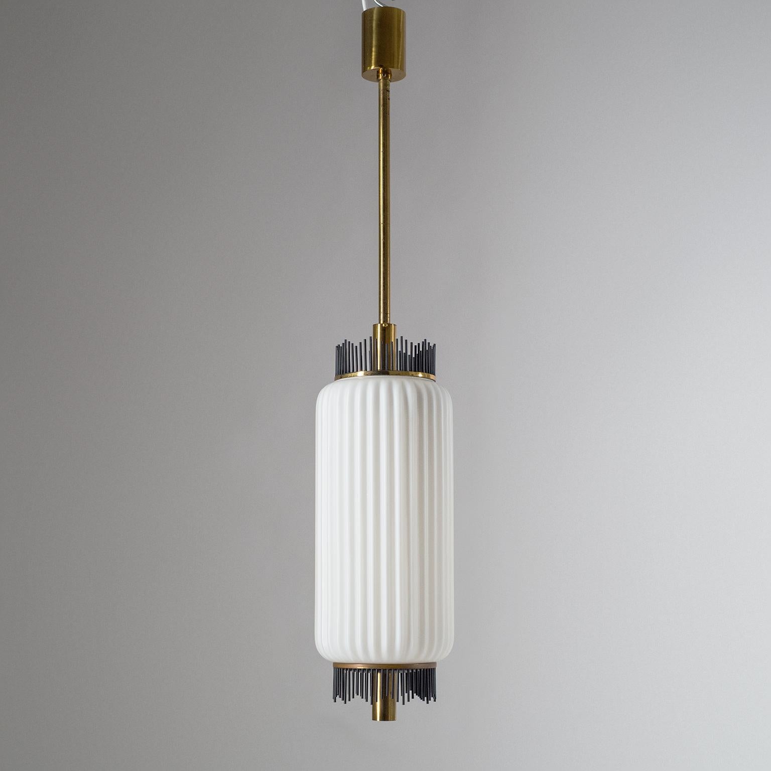 Rare Angelo Lelii pendant for Arredoluce, circa 1959. Composed of a large ribbed satin glass diffuser and brass hardware with graphical black lacquered brass finials on both ends of the glass. Very nice original condition with some patina on the