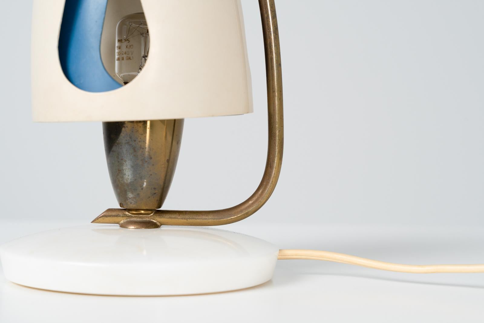 Très belle lampe de table par Angelo Lelii et fabriquée par Arredoluce en 1952. La lampe elle-même est faite d'aluminium, de laiton et a un pied en marbre. L'abat-jour peut être ajusté pour laisser passer la lumière par les trous, ce qui est une