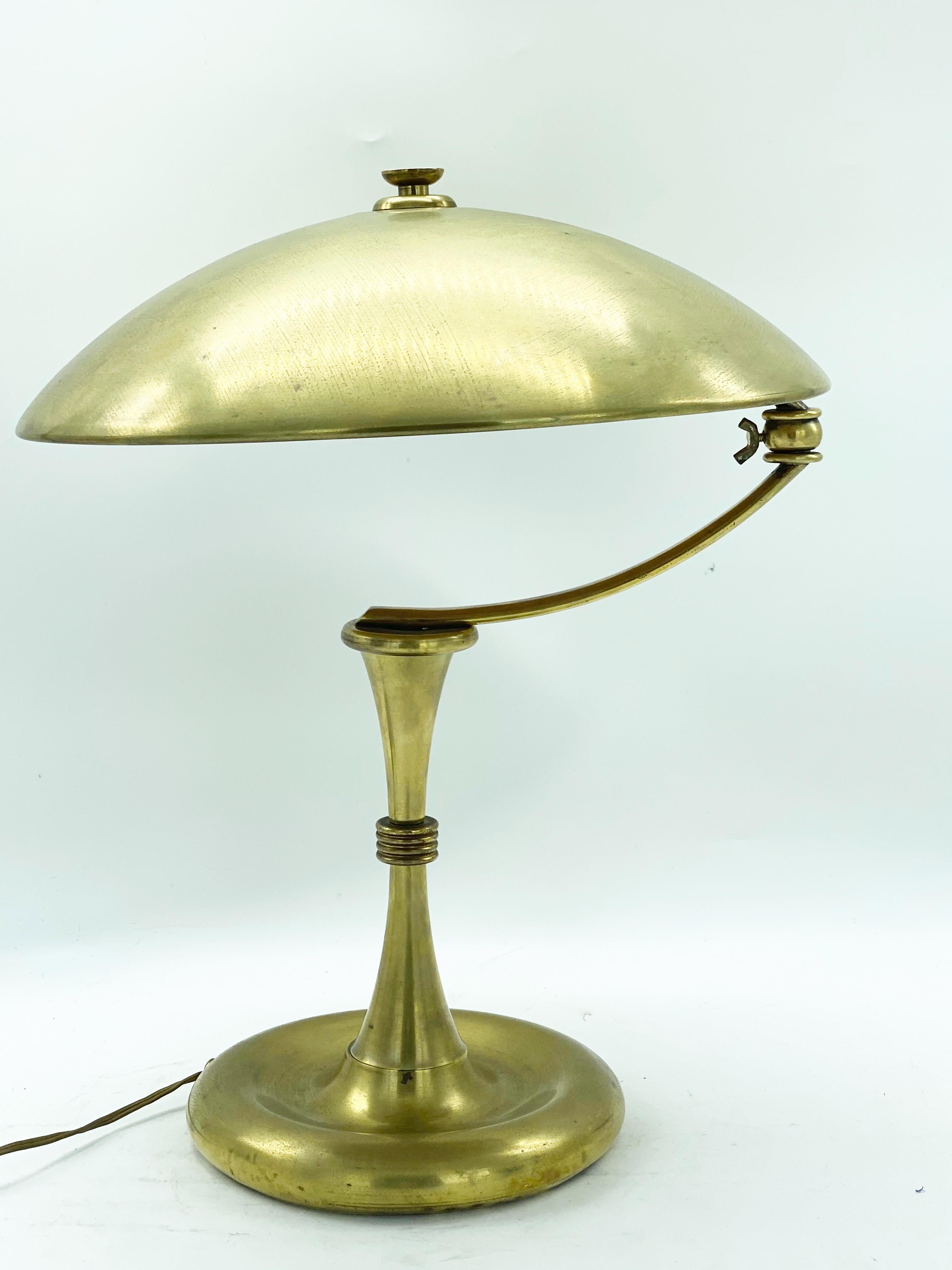 A classic desk lamp with Art Deco detail and rounded shade which swivels over the weighty base.
The brass features a characterful dark patina throughout adding warmth to any room.
Design Angelo Lelli for Arredoluce attributed.