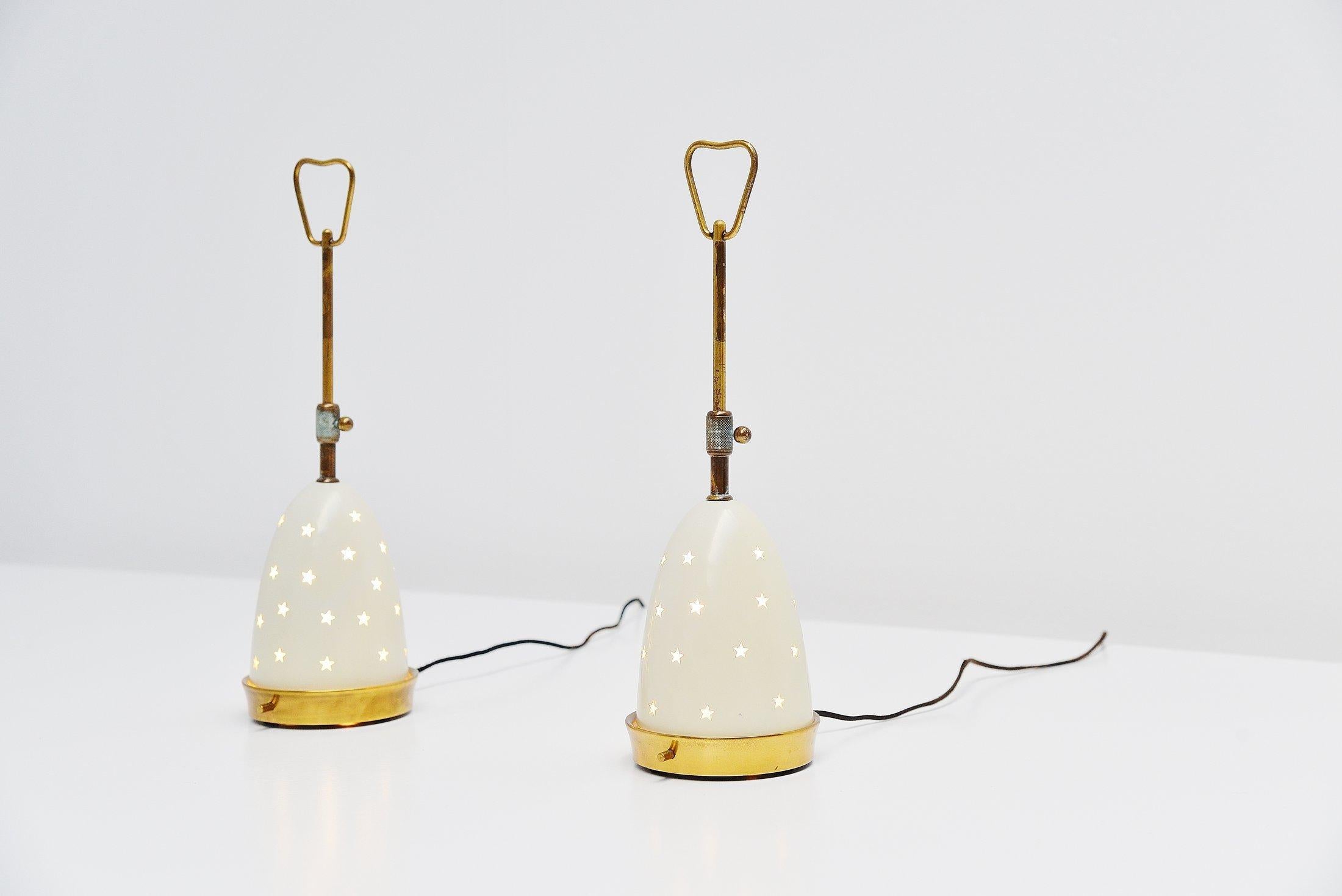 Fantastic pair of small table or bedside lamps model 12291 designed by Angelo Lelli and manufactured by Arredoluce, Italy, 1950. These lamps have a brass structure and a double shade in frosted glass and metal. The outer shade has a die cut star