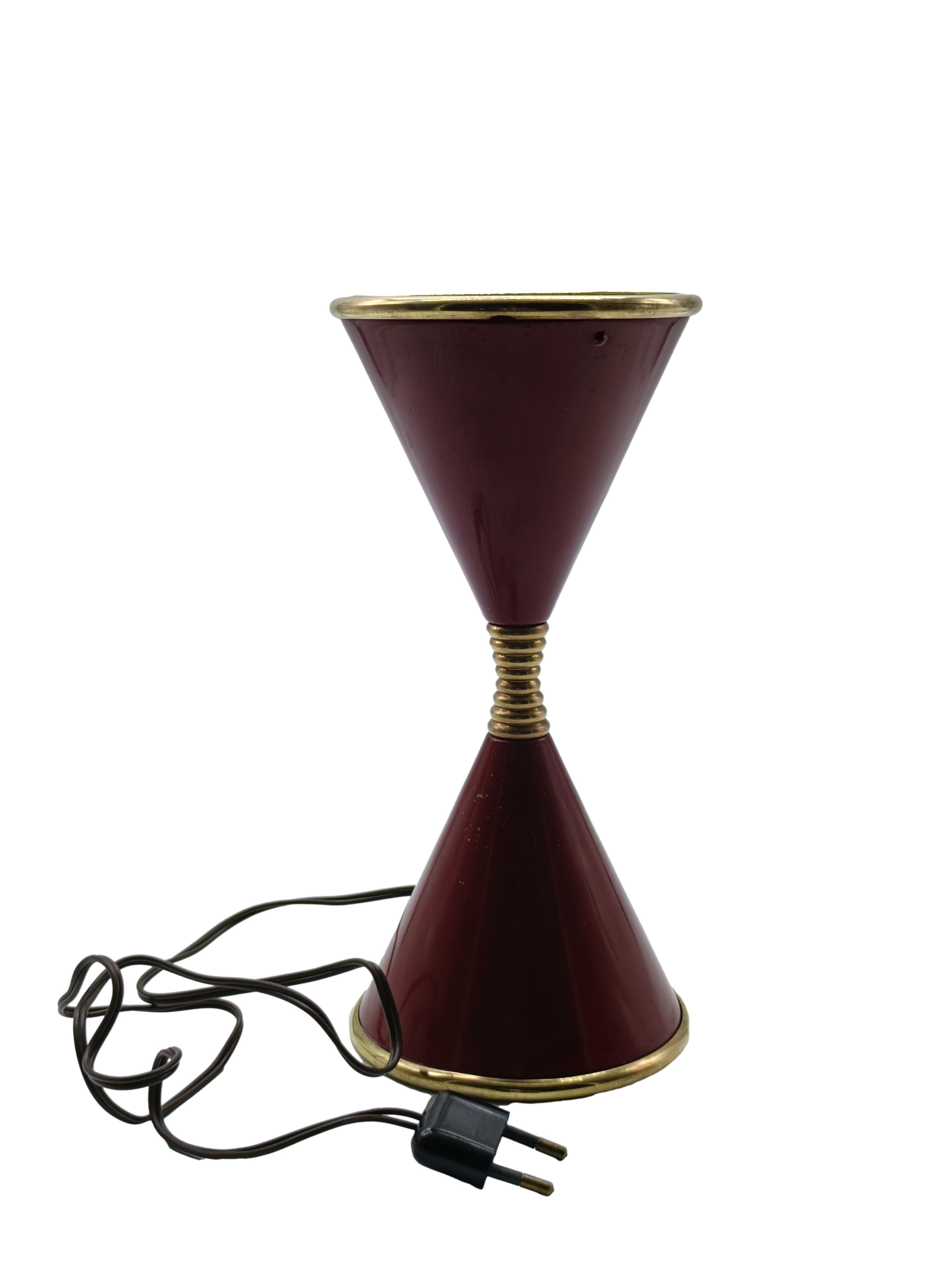 Splendida e rara lampada da tavolo Mod. Clessidra,  disegnata da Angelo Lelii per Arredoluce, prodotta all'inizio degli anni '60
La lampada e' in metallo smaltato di colore bordeaux, con dettagli in ottone e vetro sabbiato nella parte superiore per