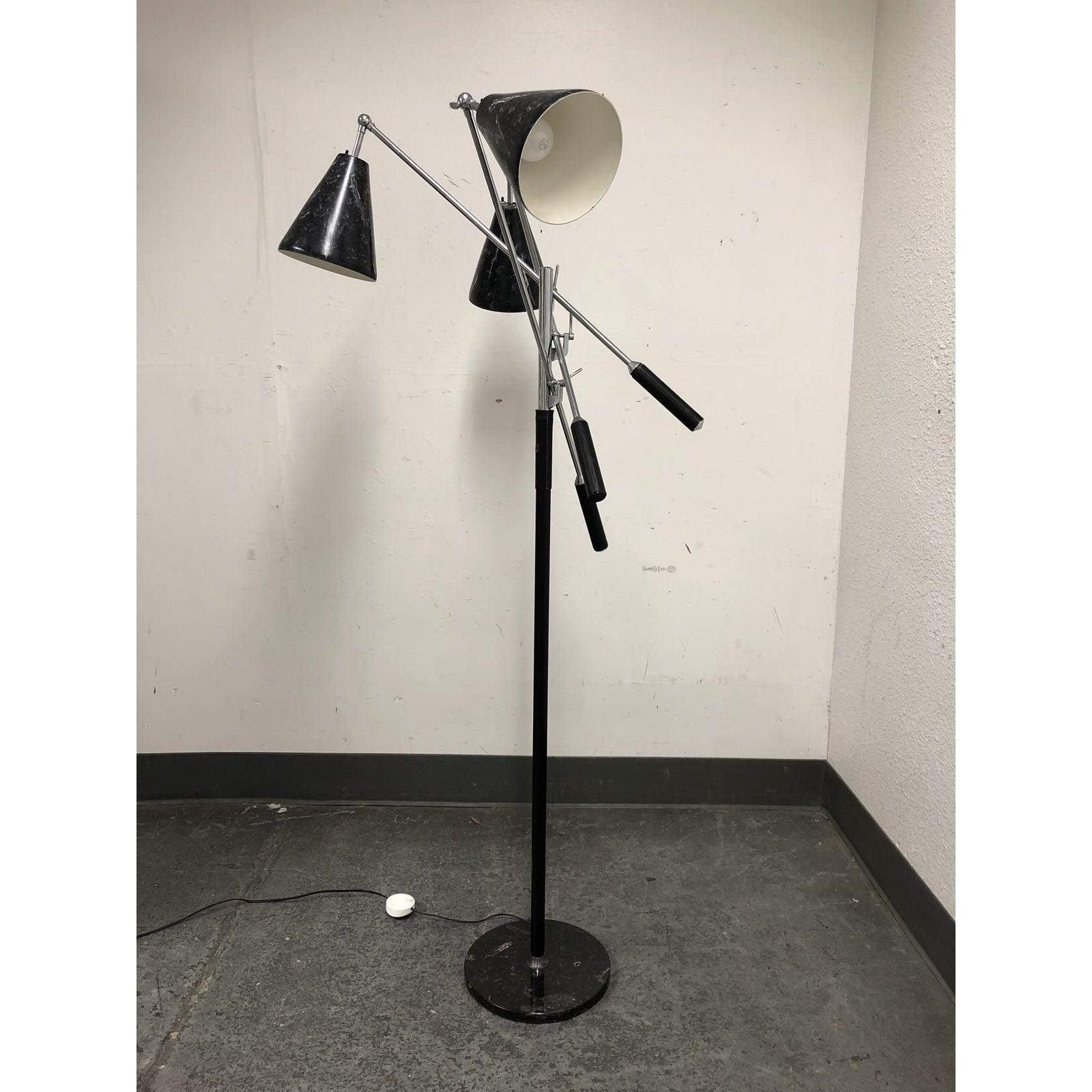Presents a mid-20th century Triennale floor lamp. A design statement originally designed by Angelo Lelli for Arredoluce. Originally purchased in the 1960s. A three arm Triennale floor lamp with faux black and white marble cone shaped shades, chrome
