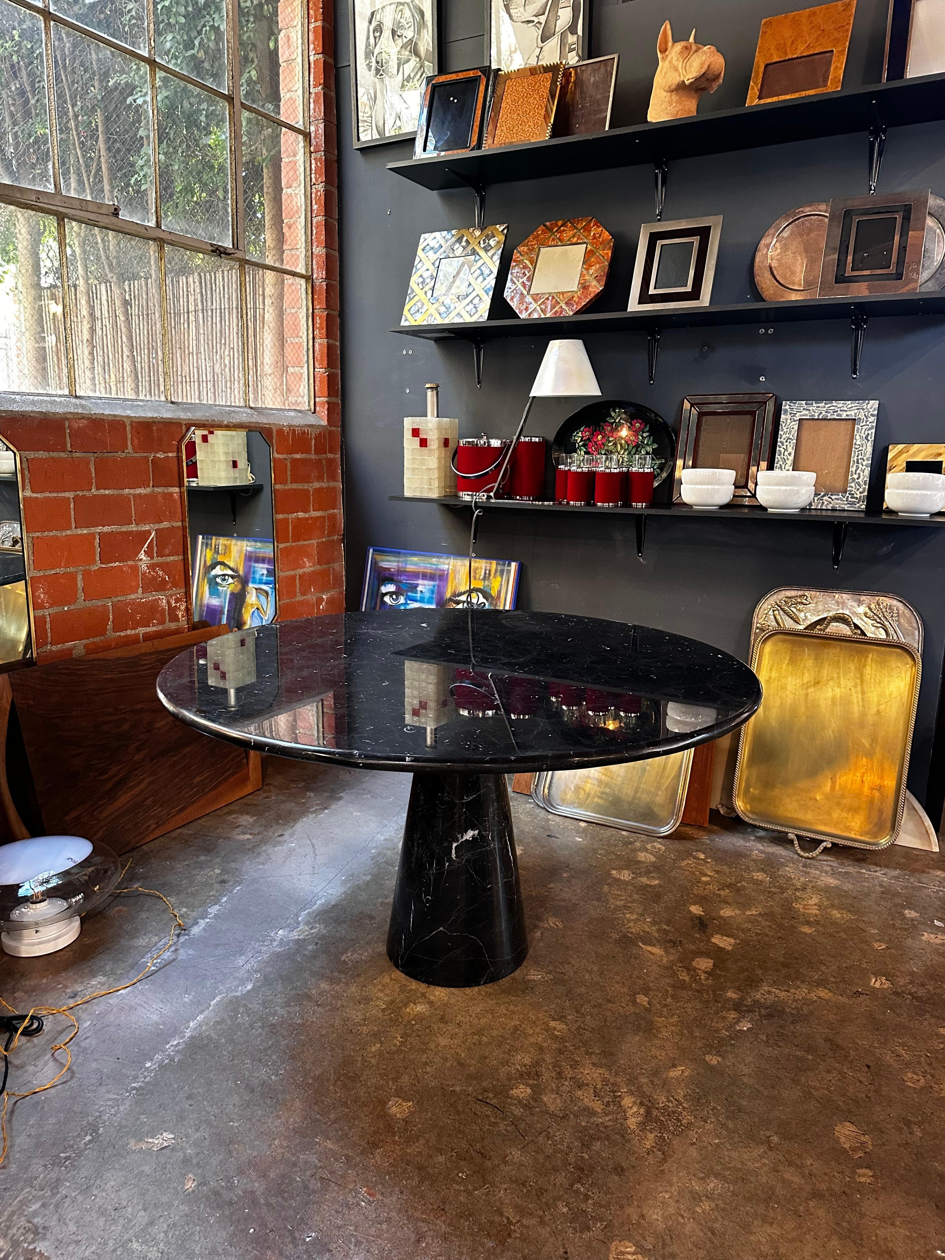 The Angelo Mangiarotti Black Marquina Marble Round Dining Table from the 1970s is a classic piece of Italian design. Designed by Angelo Mangiarotti, a renowned architect and designer, this dining table features a round top made of high-quality Black