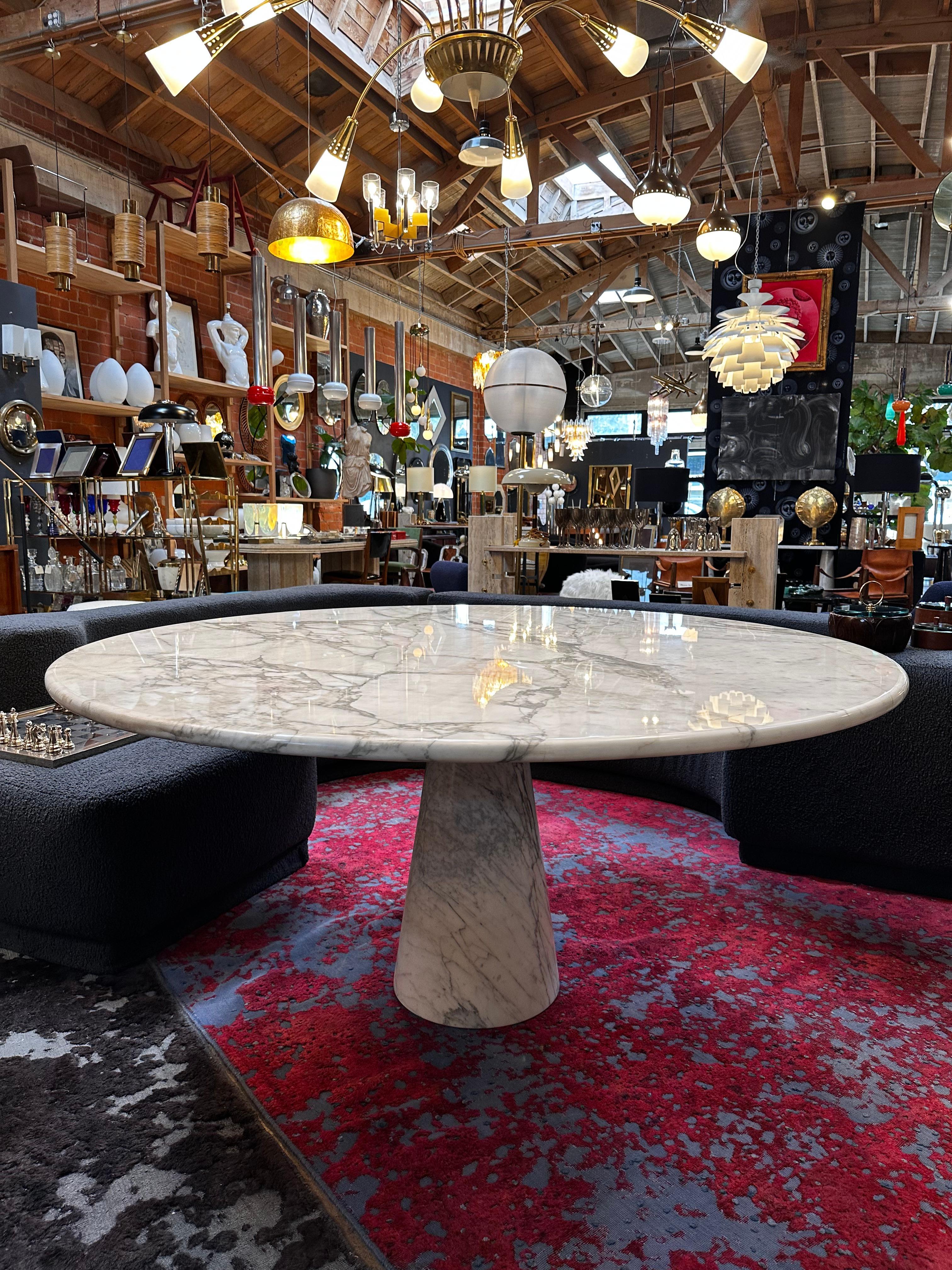 The Angelo Mangiarotti Calacatta Marble Round Oversize Dining Table from the 1970s is a stunning exemplar of Italian design and craftsmanship. This exceptional dining table features a generously proportioned round top meticulously crafted from