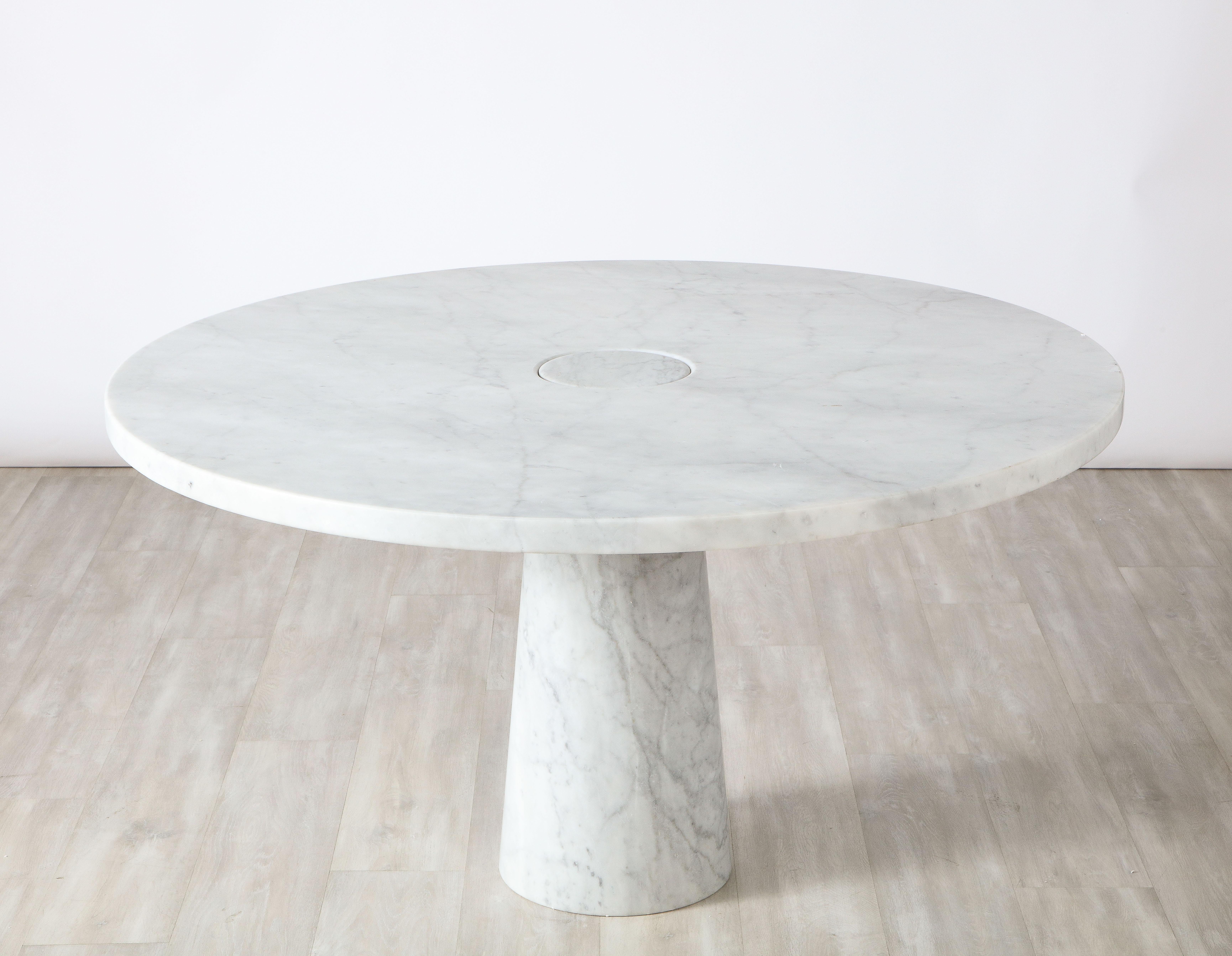 A Carrara marble pedestal dining table, Attributed to Angelo Mangiarotti for Skipper, Italy, 1970's. This circular table features no joints or clamps and is architecturally grand in its structure, featuring a singular conical pedestal that is