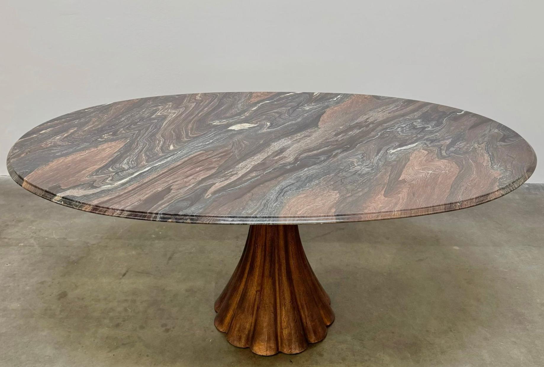A vintage 1980’s marble top dining table with a copper colored iron base in the style of Angelo Mangiarotti. The marble is stunning and the grain seems to flow with movement. The copper toned iron base is perfectly suited to the color of the top.