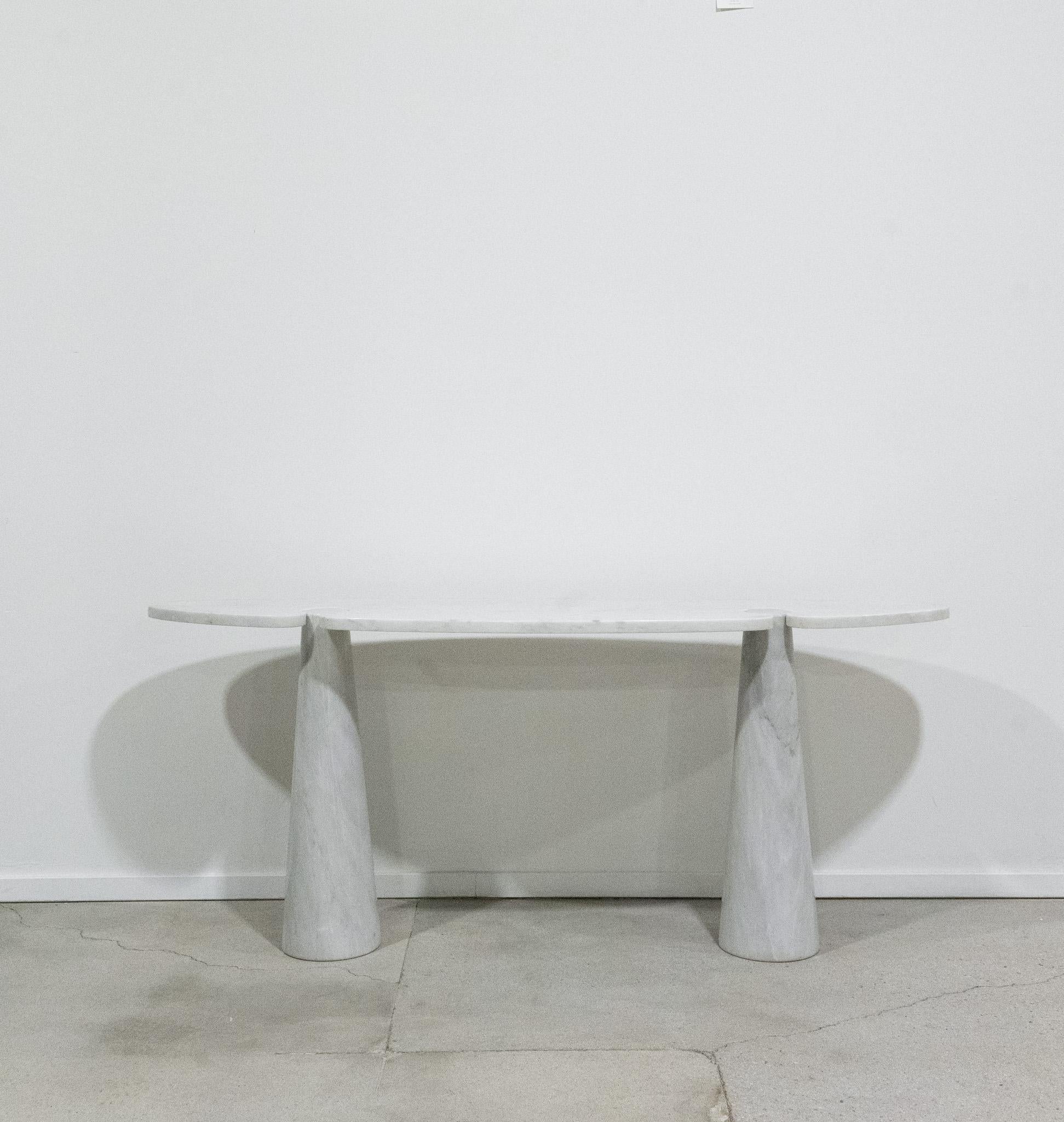 Incroyable table conçue par Angelo Mangiarotti pour Skipper de la série Eros, table console iconique en marbre de Carrare avec un grand plateau elliptique monté sur deux bases coniques. 

Vintage original.

Nous avons un expéditeur hebdomadaire pour