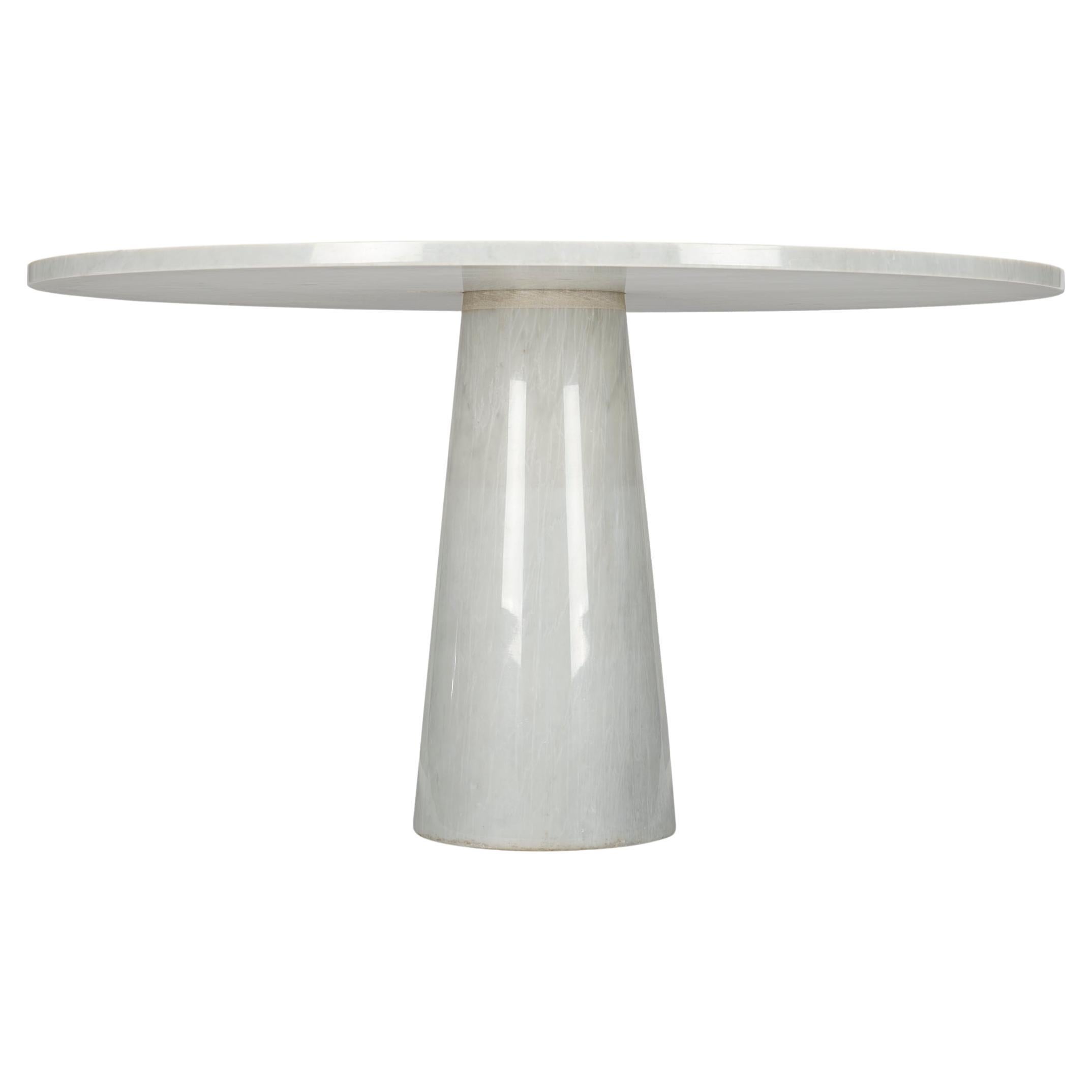 This sculptural table by architect Angelo Mangiarotti is executed in solid white Carrara marble. The table top rests on one cone-shaped leg in the middle. The top 'locks' itself onto the marble cone and keeps in place because of the weight of the