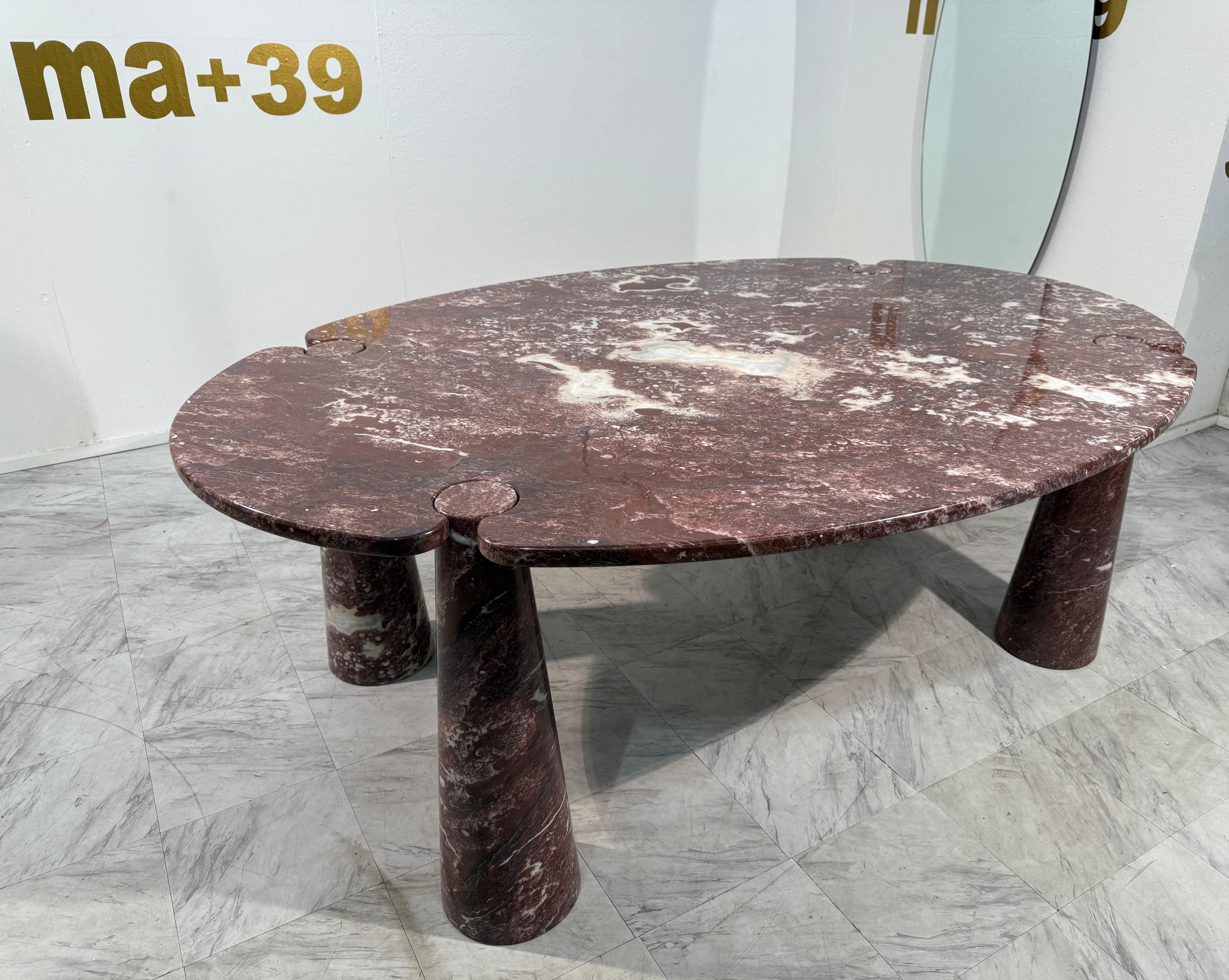 Una escultural mesa de comedor italiana de la emblemática serie Eros de Angelo Mangiarotti, diseñada en la década de 1970. Realizada en mármol Rosso Levanto, esta mesa ovalada presenta la característica construcción por gravedad de Mangiarotti, en