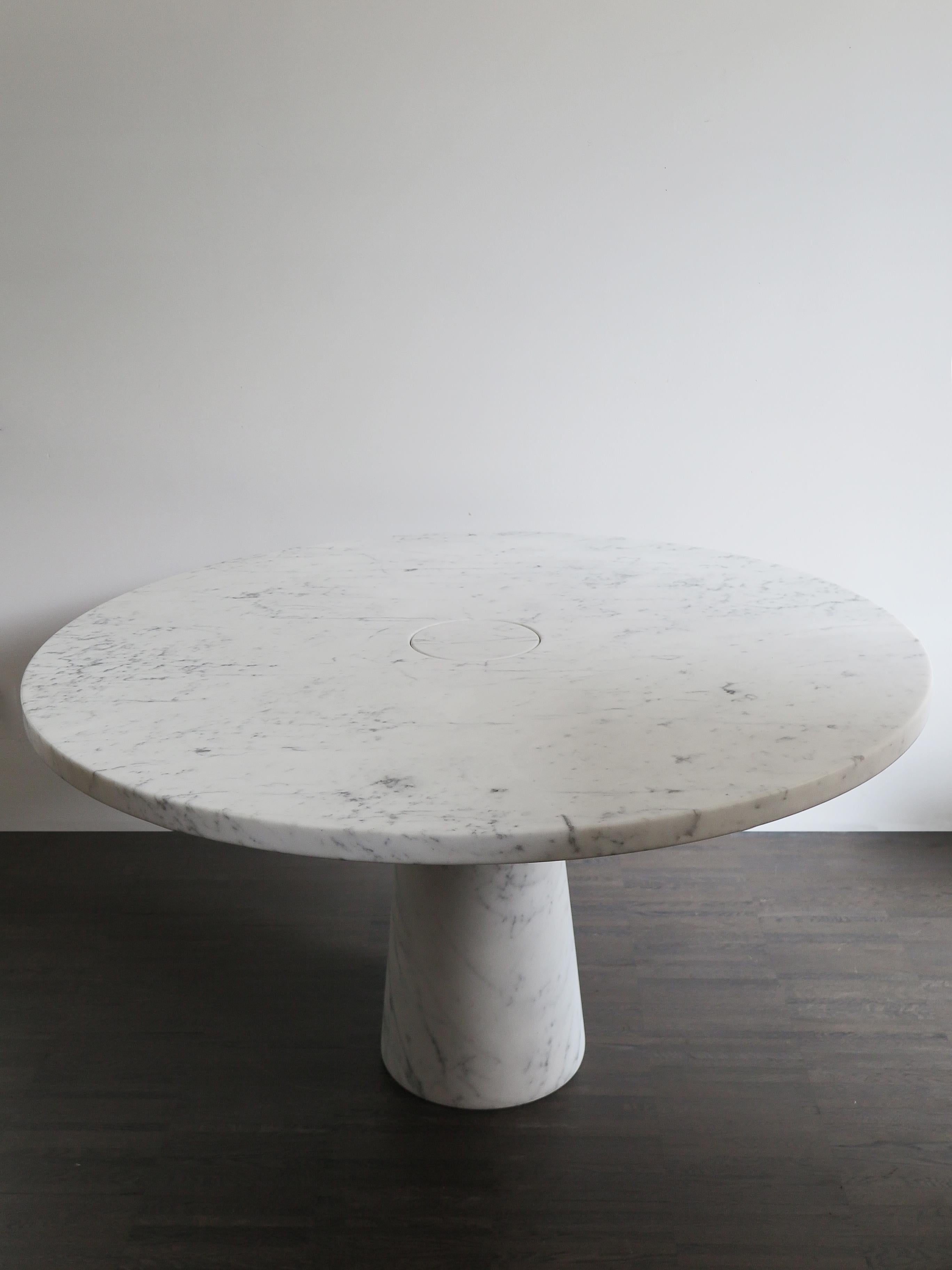 Table italienne en marbre blanc de Carrare de la série Eros, conçue par Angelo Mangiarotti en 1971. La table Eros implique un encastrement par gravité entre le plateau et le pied, rendu possible par la section tronconique du pied lui-même, qui