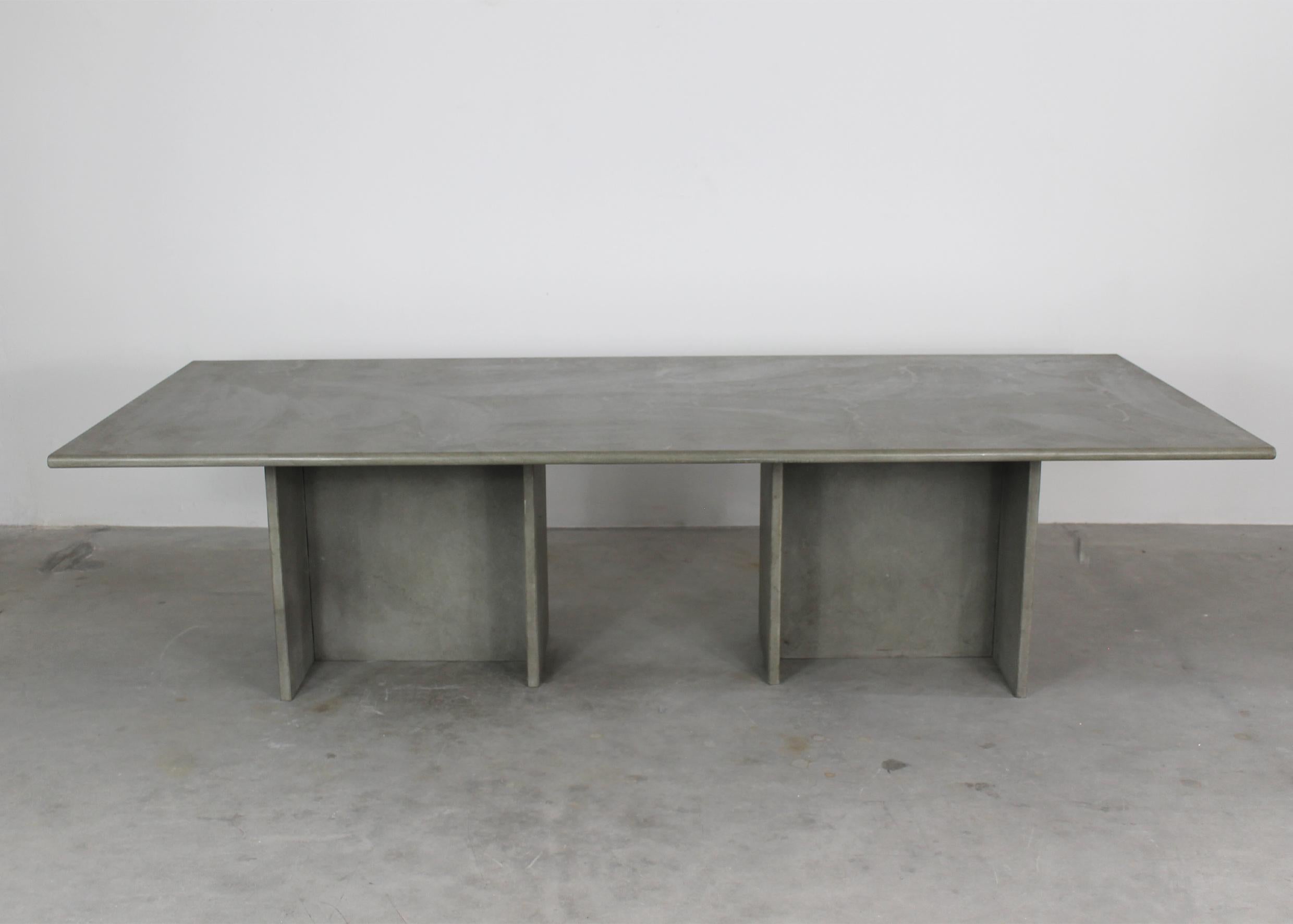 A large table in sandstone with a rectangular-shaped tabletop and two-column legs. 
Attributed to Angelo Mangiarotti and produced by an Italian manufacturer in the 1970s.
 
Angelo Mangiarotti was born in Milan on 26th of February 1921.

He graduated