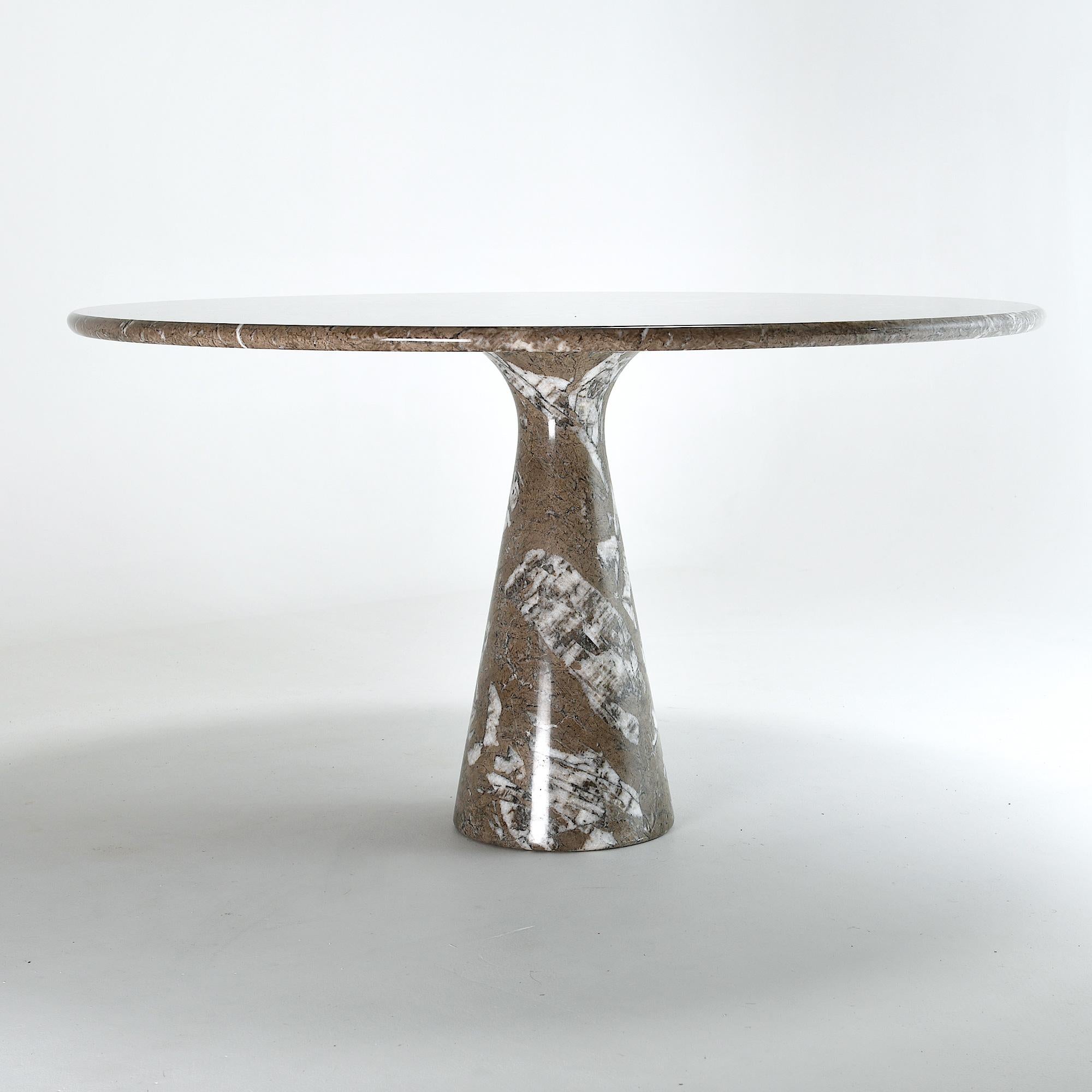 Round marble dining table on diabolo shaped pedestal leg.
Designed in 1960 by Angelo Mangiarotti, well known for his ingeneer skills .
The challenge for the M1 was to keep the minimum material in the foot to hold the table top.
The result is this