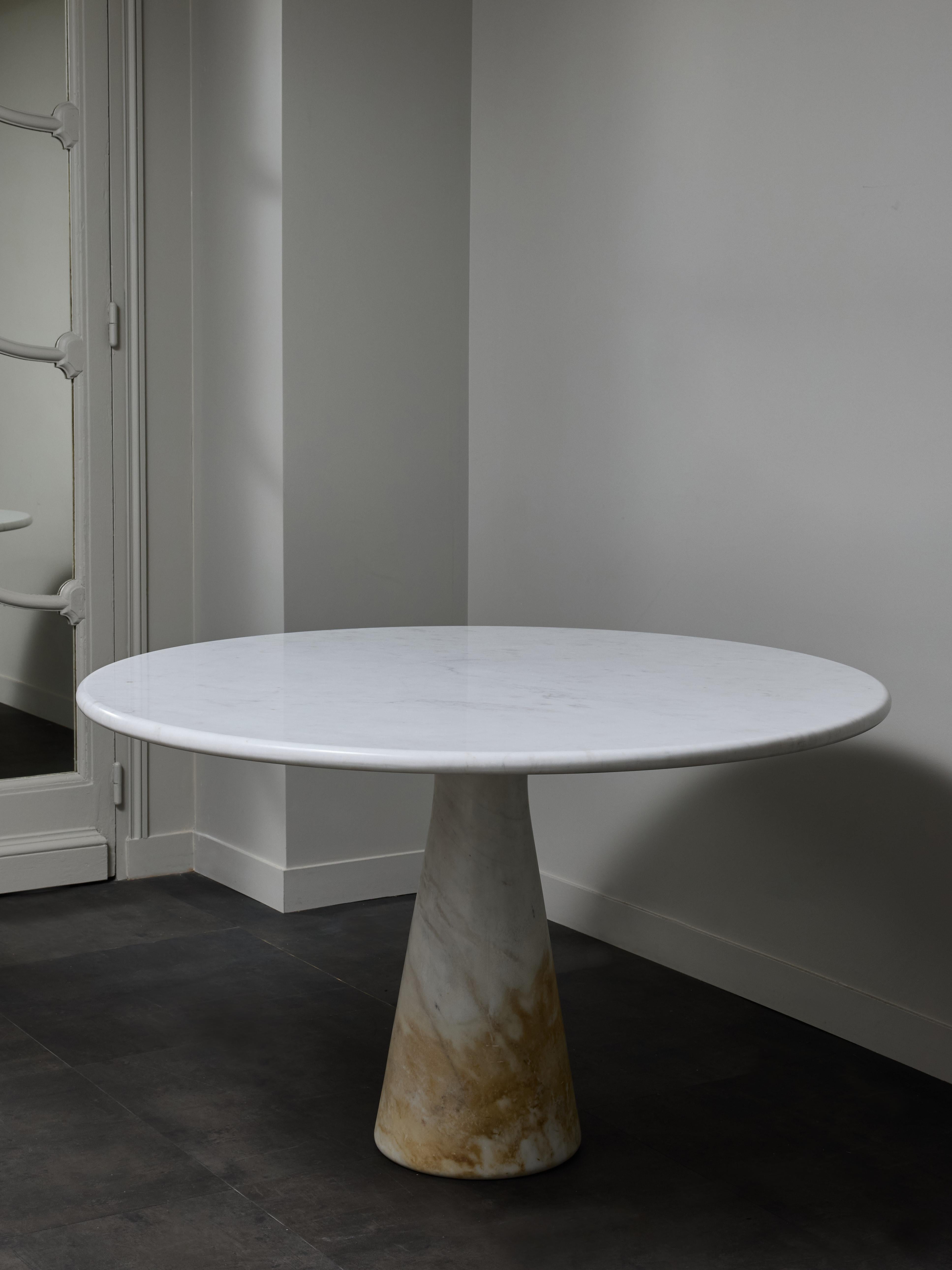 Guéridon en marbre blanc conçu par Angelo Mangiarotti dans les années 1970.

Deux éléments composent cette table, un pied conique qui s'élargit au sommet et s'enfonce dans le plateau rond, lui conférant ainsi sa stabilité.

Pour quatre à six
