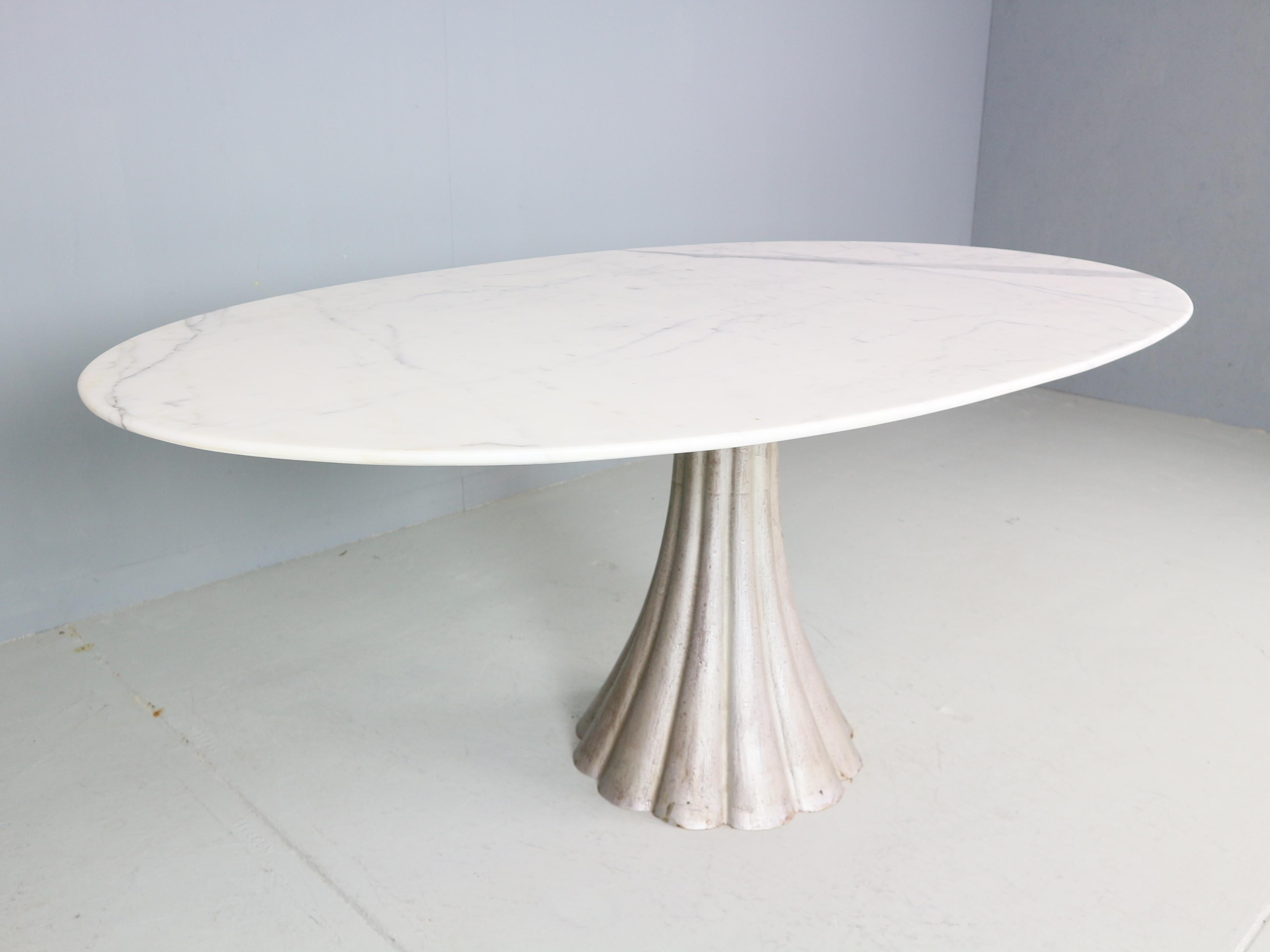 Magnificent Oval shape dinning table designed by Angelo Mangiarotti in 1970's Italy.
The oval shaped carrara marble tabletop shows a beautiful play of natural grey and white colors. The pedestal table is constructed with a scalloped shaped base,