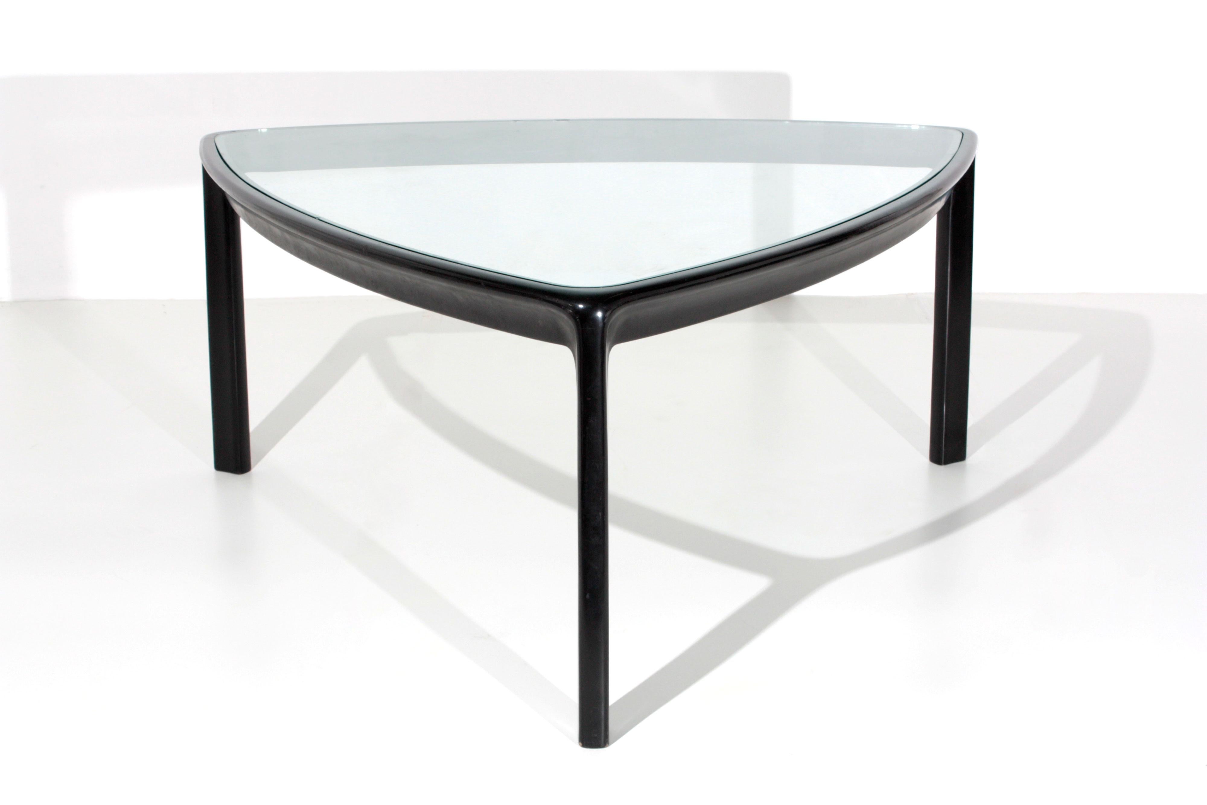 Large table designed by Angelo Mangiarotti for the Skipper production. The table has a slightly rounded triangular shape. Its structure is in wood with three pedestals. As a support base we find a glass top. The table is ideal to define living room
