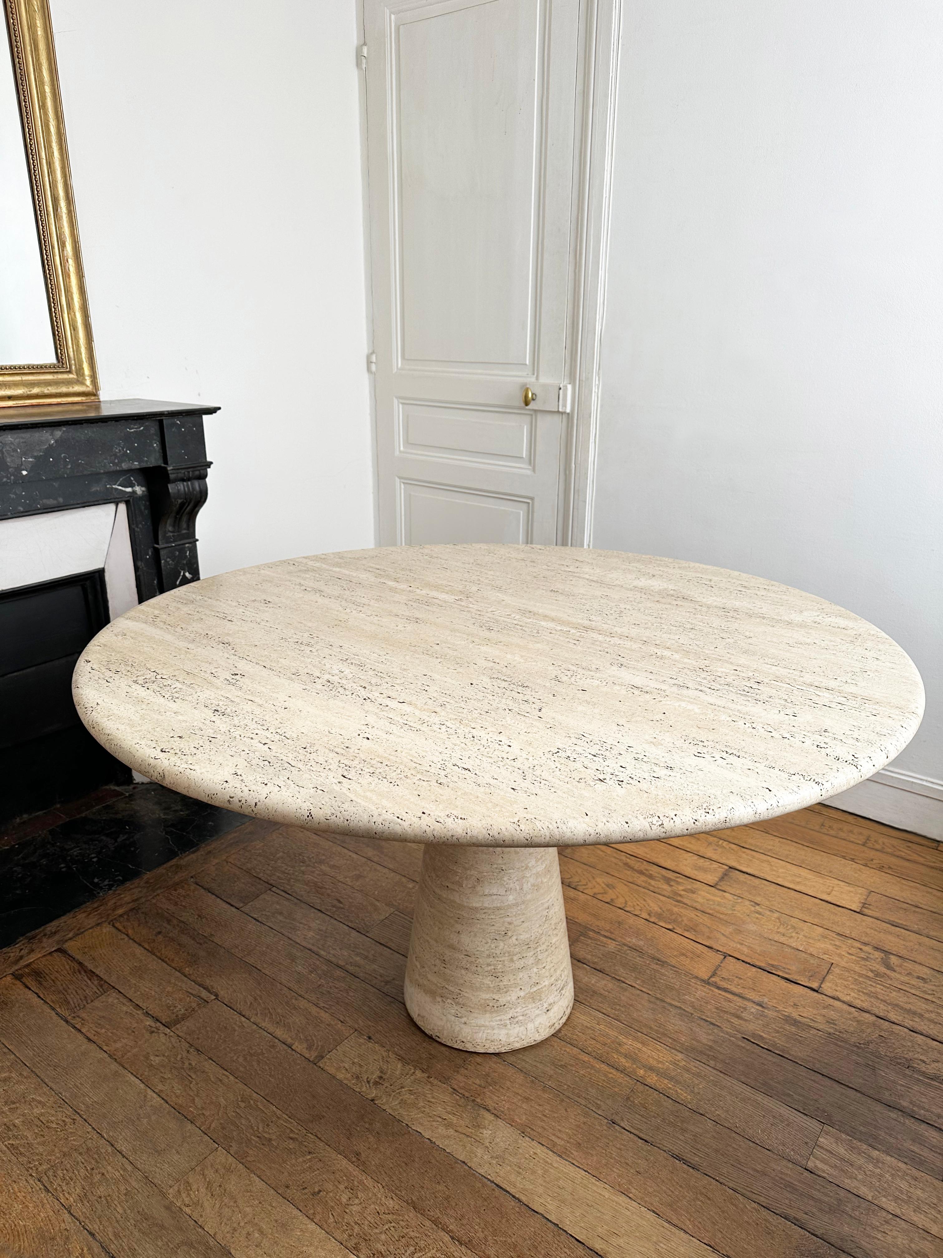 Large round table suitable as a dining table for 4-6 seats or as a center piece table in an entrance or foyer. 
Made from solid travertine with a 3cm thick tabletop with filleted edge, this table features a single conical pedestal structure, also