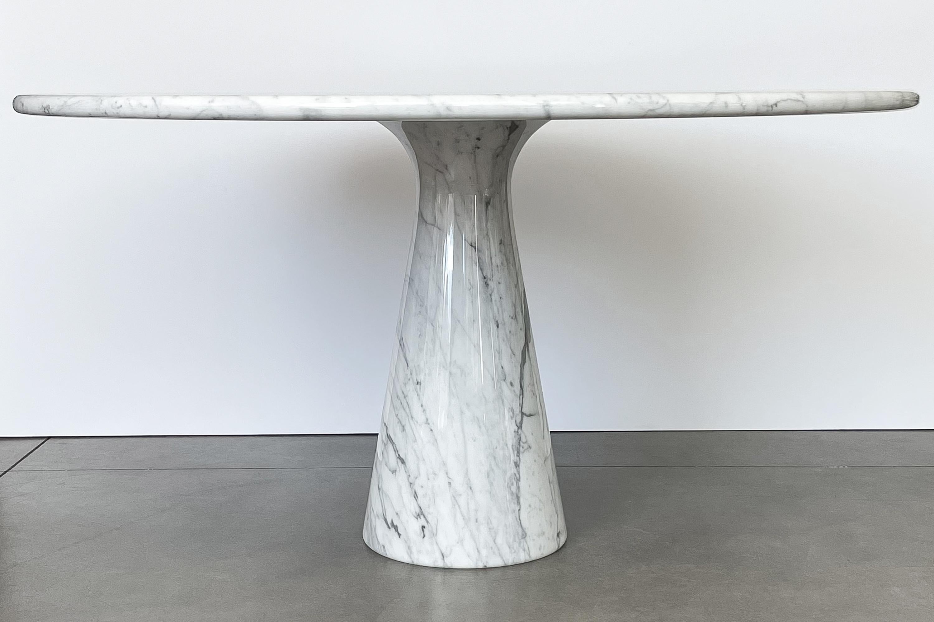 A beautiful Angelo Mangiarotti white Carrara marble M1 pedestal dining table for Skipper, Italy circa 1970s. Stunning white Carrara marble with striking gray veining. A round 1.25 inch thick top sits on single truncated conical marble pedestal which