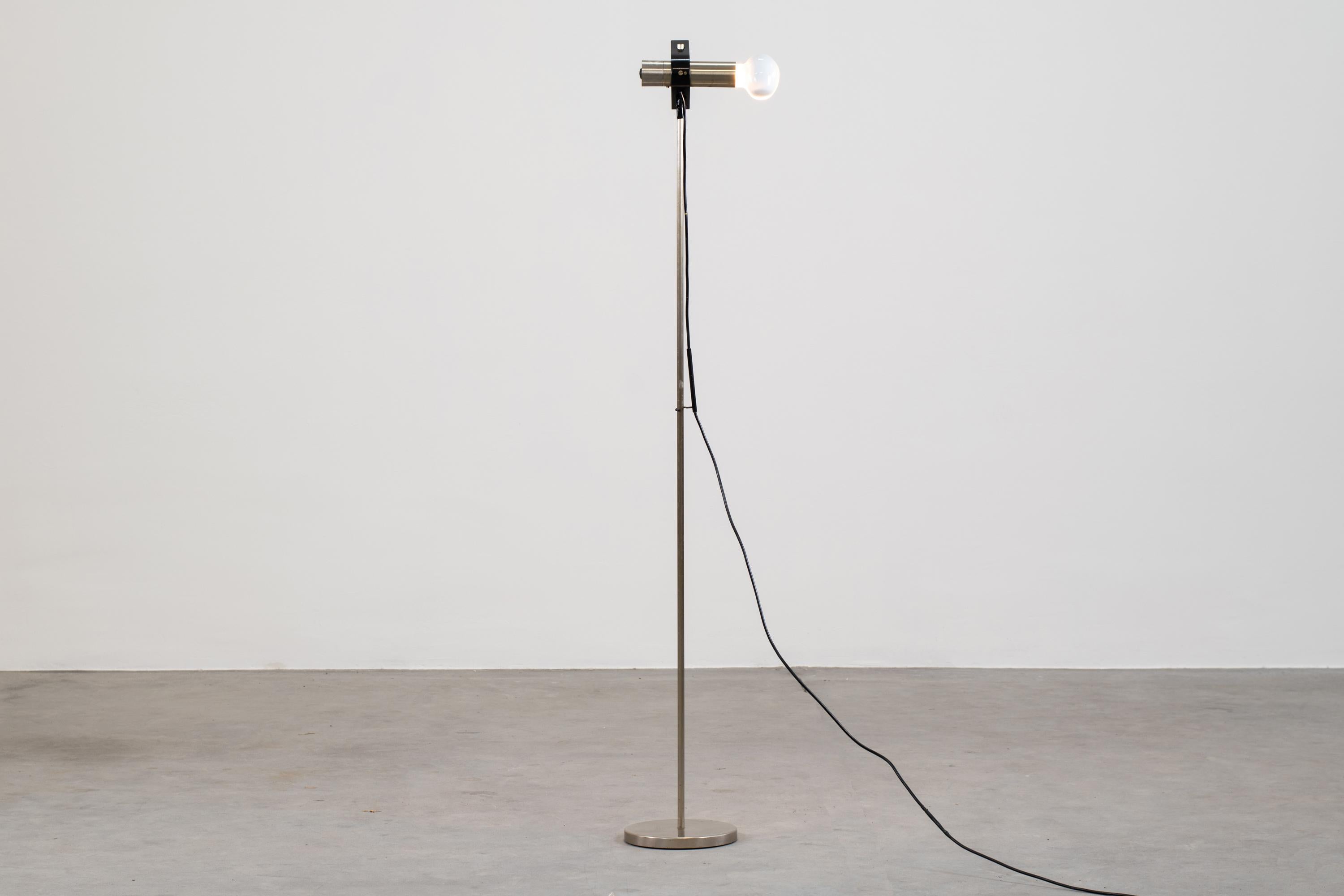 Floor lamp model 399 (from cornalux series) with structure in nickel-plated metal, lacquered metal and cast iron.

The lamp bulb is adjustable in height achieved by a bracket that allows the lamp to be slid up and down the lamp stem.

This lamp was