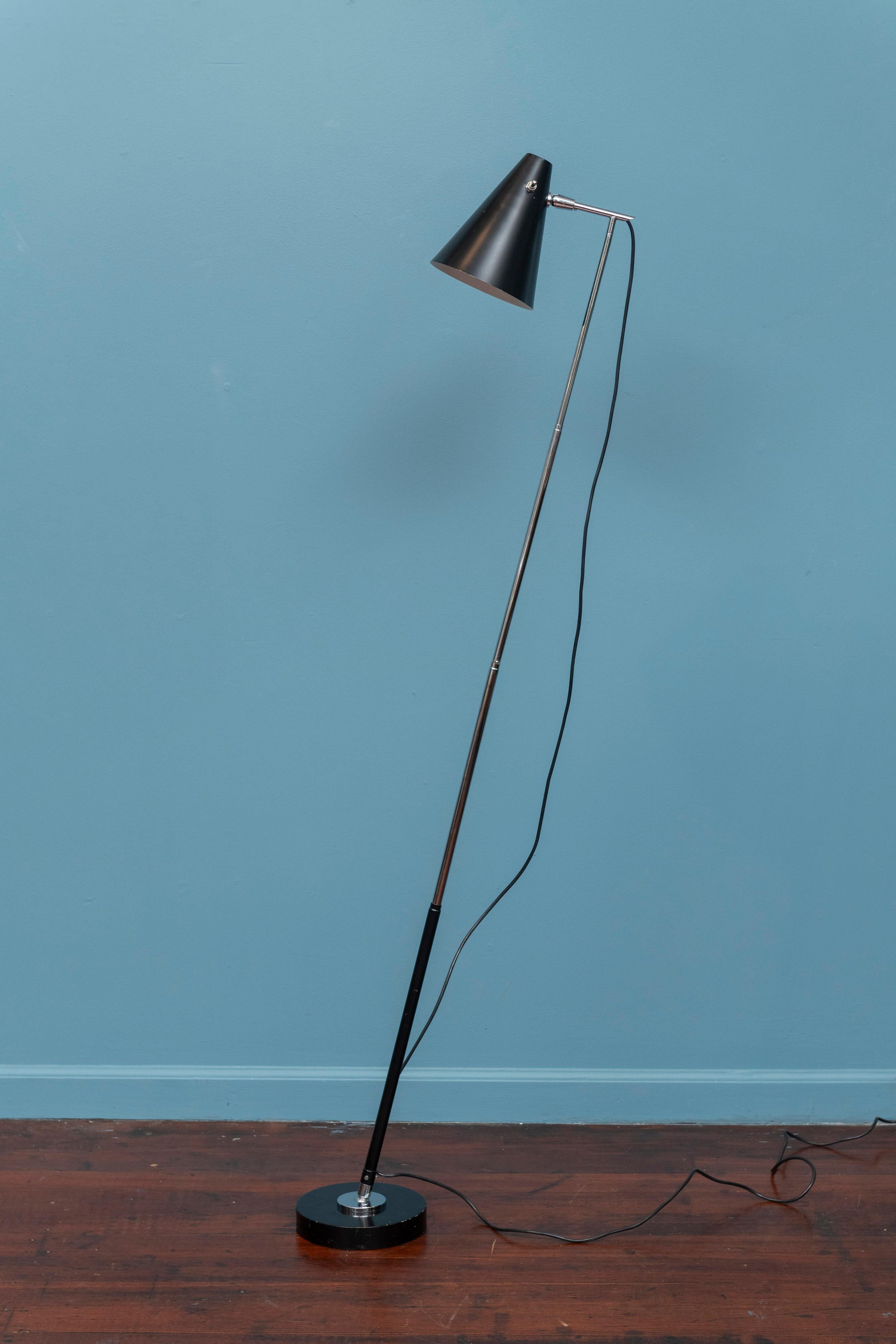 Angelo Ostuni model 201 telescopic floor and table lamp designed for OLuce, circa 1980. This version is in black with chrome mounts and stem, a cast steel base and tapering conical shade with button switch. The telescopic stem allows the height to