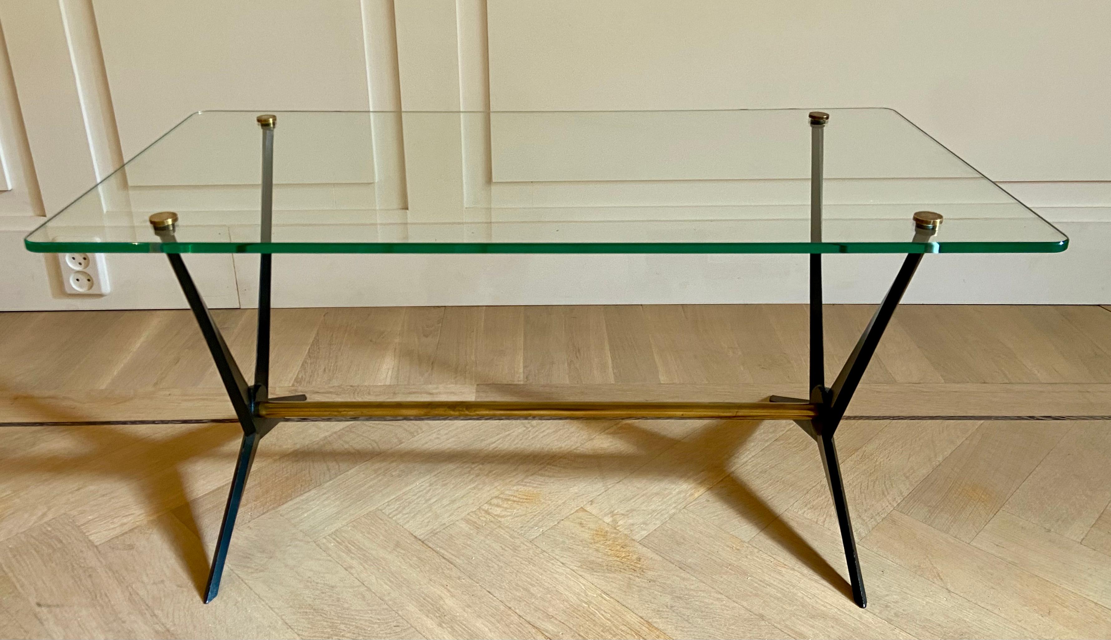 Coffee table by Angelo Ostuni. Angular black enameled aluminium frame
with brass embellishments. Attached square glass is pierced and capped with four round brass caps.