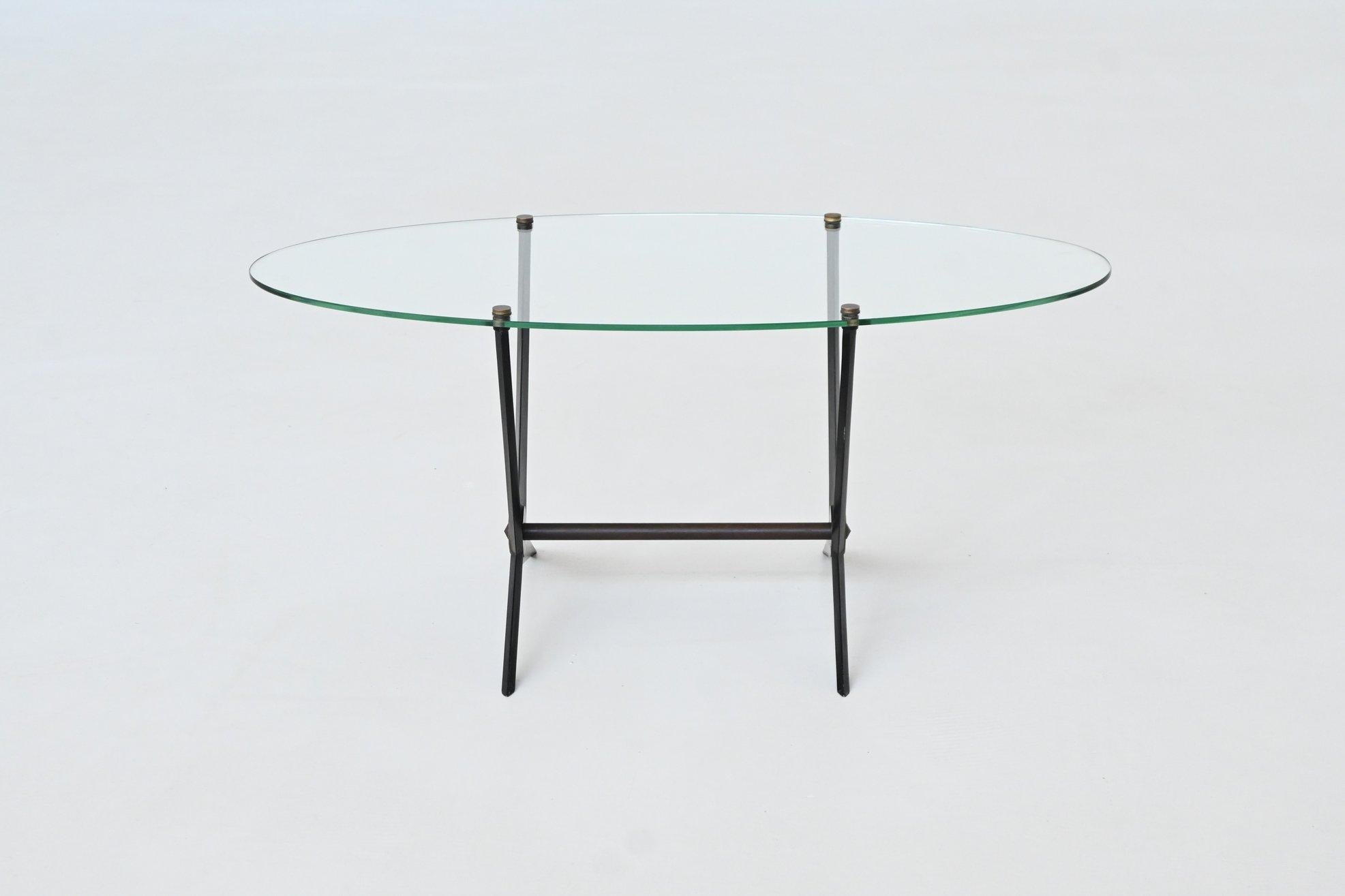 Chic and sophisticated Italian oval shaped coffee table designed and manufactured by Angelo Ostuni, Italy 1950. This piece exudes a dynamic midcentury look, with its simple angular and graphic design language as well as material choices in the form